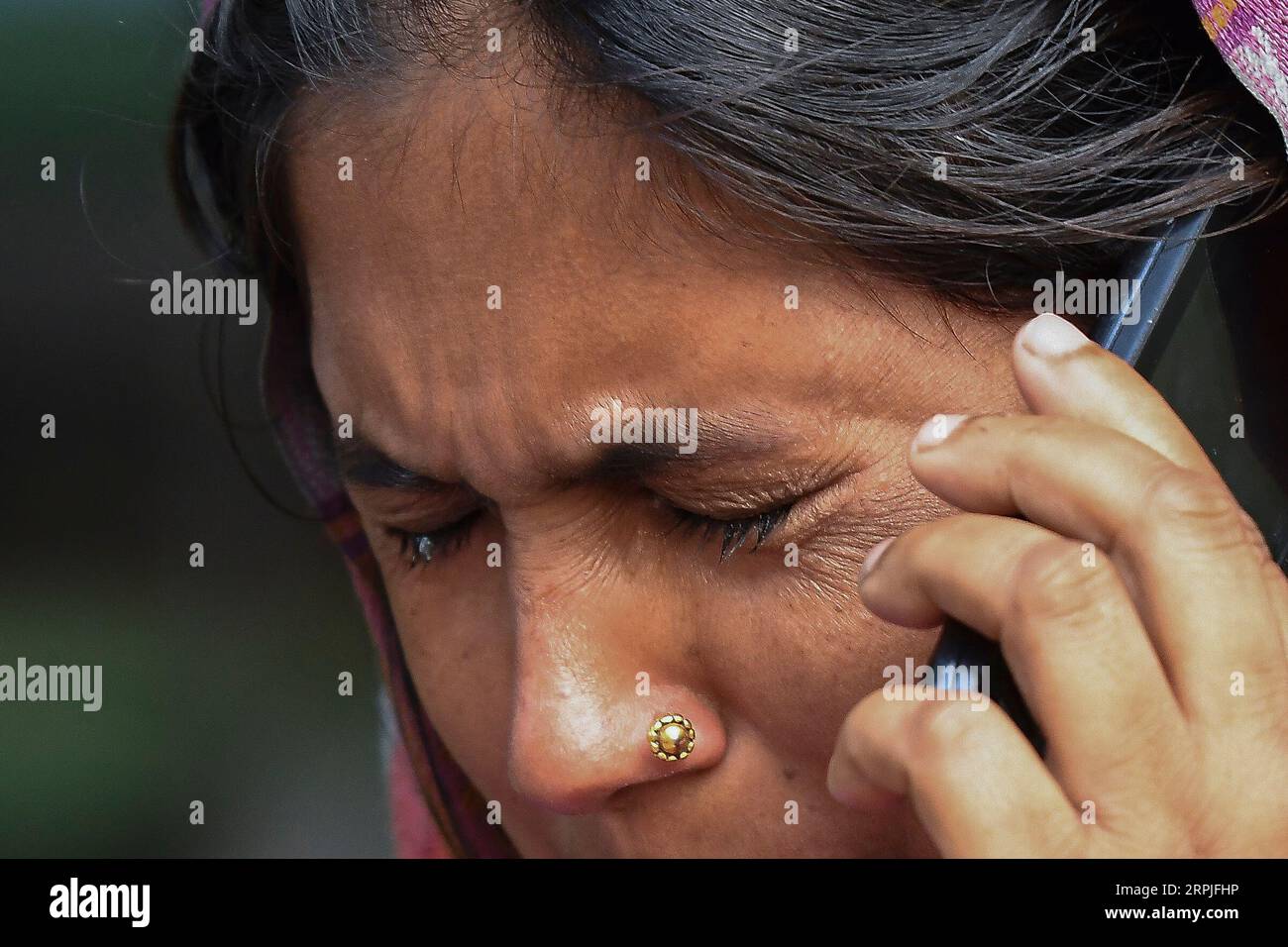 191208 -- NEW DELHI, Dec. 8, 2019 -- A relative of a fire victim speaks on the phone as she waits outside a mortuary in New Delhi, India, Dec. 8, 2019. At least 43 people died and more than 50 injured in the fire incident. The injured are undergoing medical treatment at four different hospitals. The fire broke out in north Delhi s Filmistan area in the early hours of Sunday when more than 100 people, mostly labourers, were asleep inside a four-storey building. Str/Xinhua INDIA-NEW DELHI-FIRE VICTIMS-RELATIVES Stringer PUBLICATIONxNOTxINxCHN Stock Photo