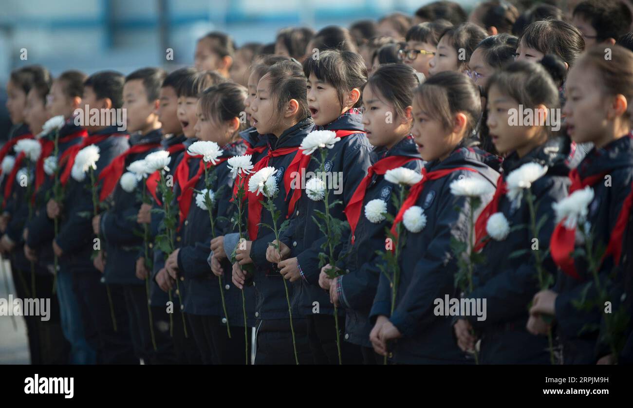 191214 -- BEIJING, Dec. 14, 2019 -- Pupils sing national anthem during a ceremony to mark China s sixth National Memorial Day for Nanjing Massacre victims at the Monument for the victims killed at the Zhongshan Dock in the massacre in Nanjing, east China s Jiangsu Province, Dec. 13, 2019.  XINHUA PHOTOS OF THE DAY LixYuze PUBLICATIONxNOTxINxCHN Stock Photo