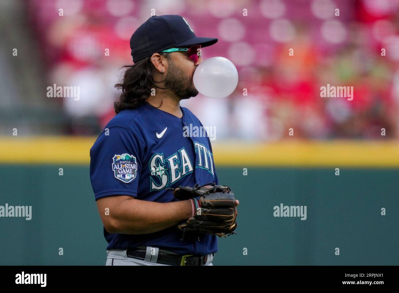 Seattle Mariners' Eugenio Suarez blows a bubble in the dugout
