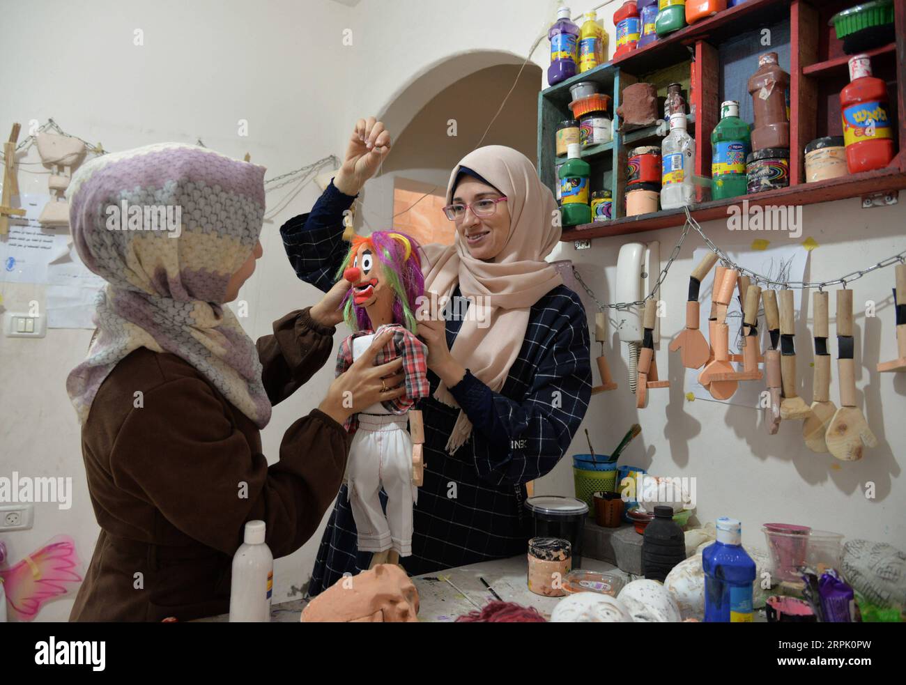 191223 -- GAZA, Dec. 23, 2019 Xinhua -- Two Palestinian girls work on a marionette at Mahdi Karira s office in Gaza City, on Dec. 23, 2019. Mahdi Karira, a 39-year-old master at making the marionette, spent 6 months on training a group of 8 girls and 2 young men to make puppets and perform puppet theater shows for children, in an attempt to promote the art of puppet theater in the Gaza Strip. Photo by Rizek Abdeljawad/Xinhua MIDEAST-GAZA-ARTIST-PUPPET THEATER PUBLICATIONxNOTxINxCHN Stock Photo