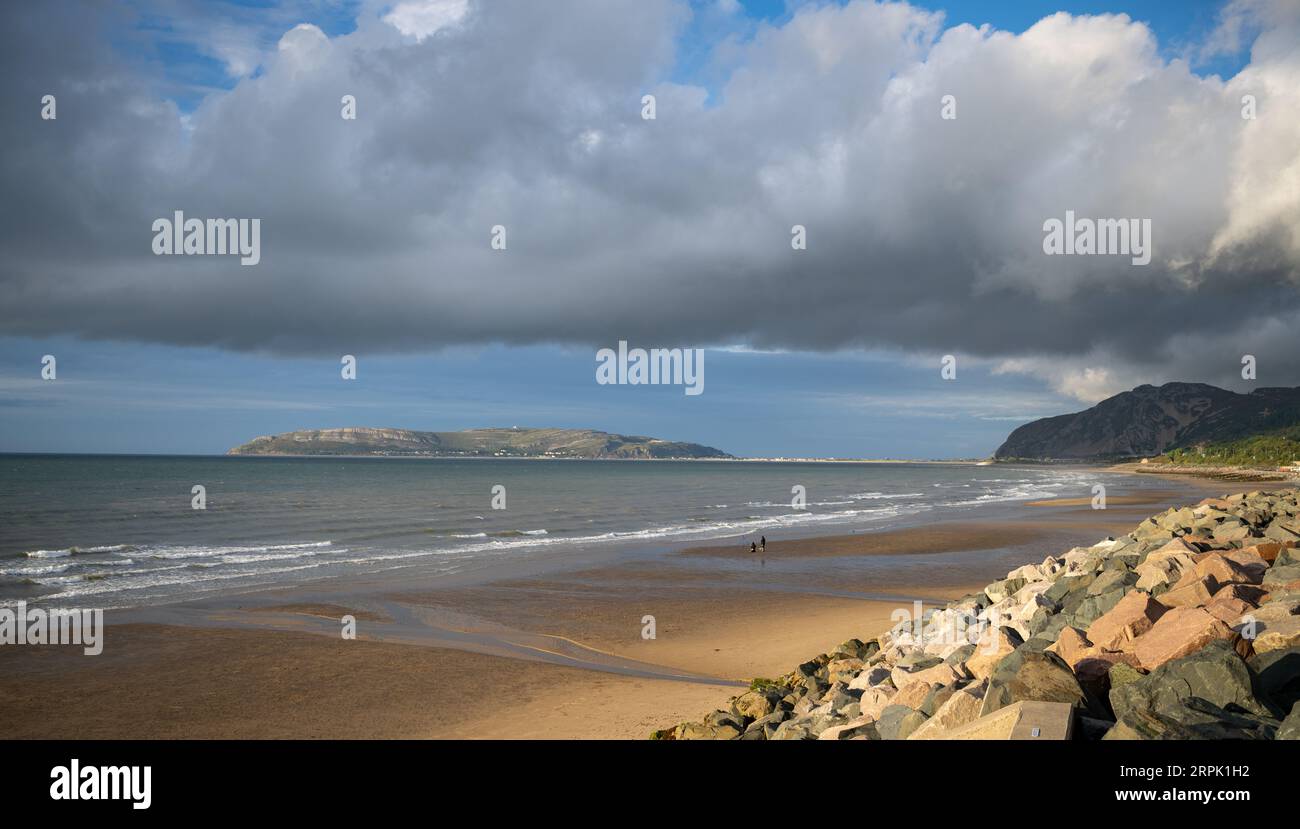 Beach at Penmaenmawr in North Wales, looking towards Llandudno and the Great Orme, on a pleasant summers evening. Stock Photo