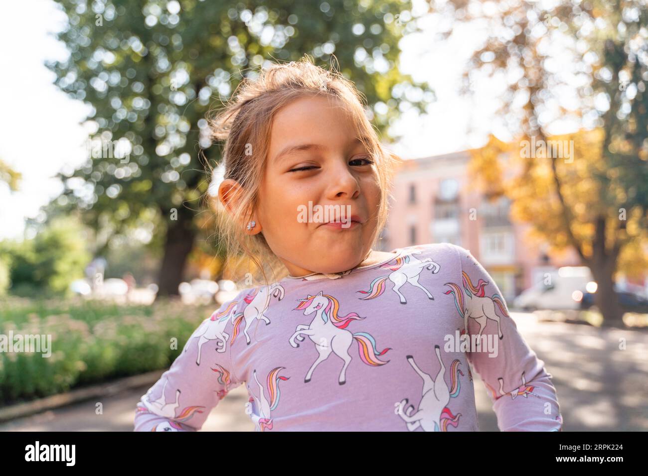 Portrait of a funny caucasian 5-6 years old girl making a face outdoors in  a city. Close-up portrait of grimacing child Stock Photo - Alamy