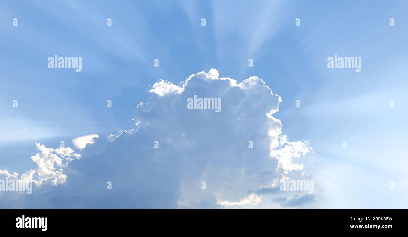 sunbeams shining through the clouds in the sky Stock Photo