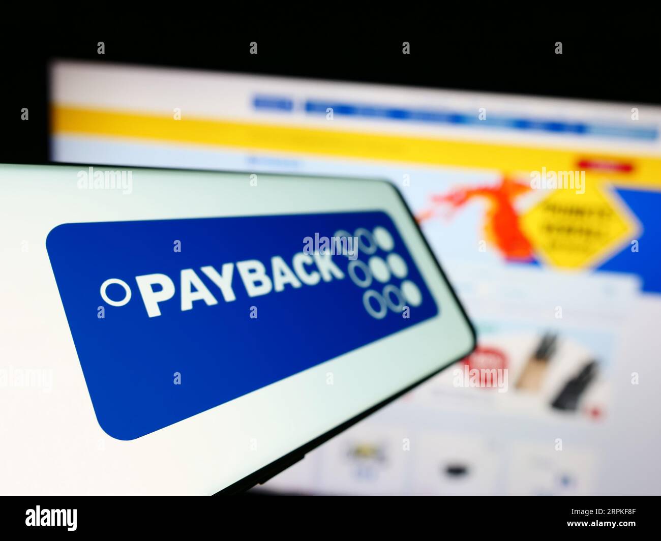 Cellphone with logo of German loyalty management company Payback GmbH on screen in front of business website. Focus on left of phone display. Stock Photo