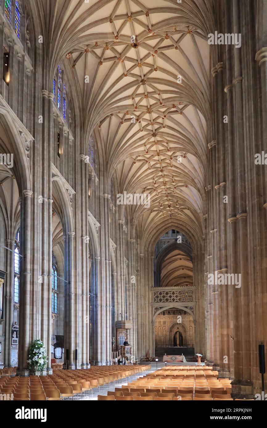 The nave of Canterbury Cathedral, view from west entrance. A priest in the pulpit speaks to an empty church. Stock Photo