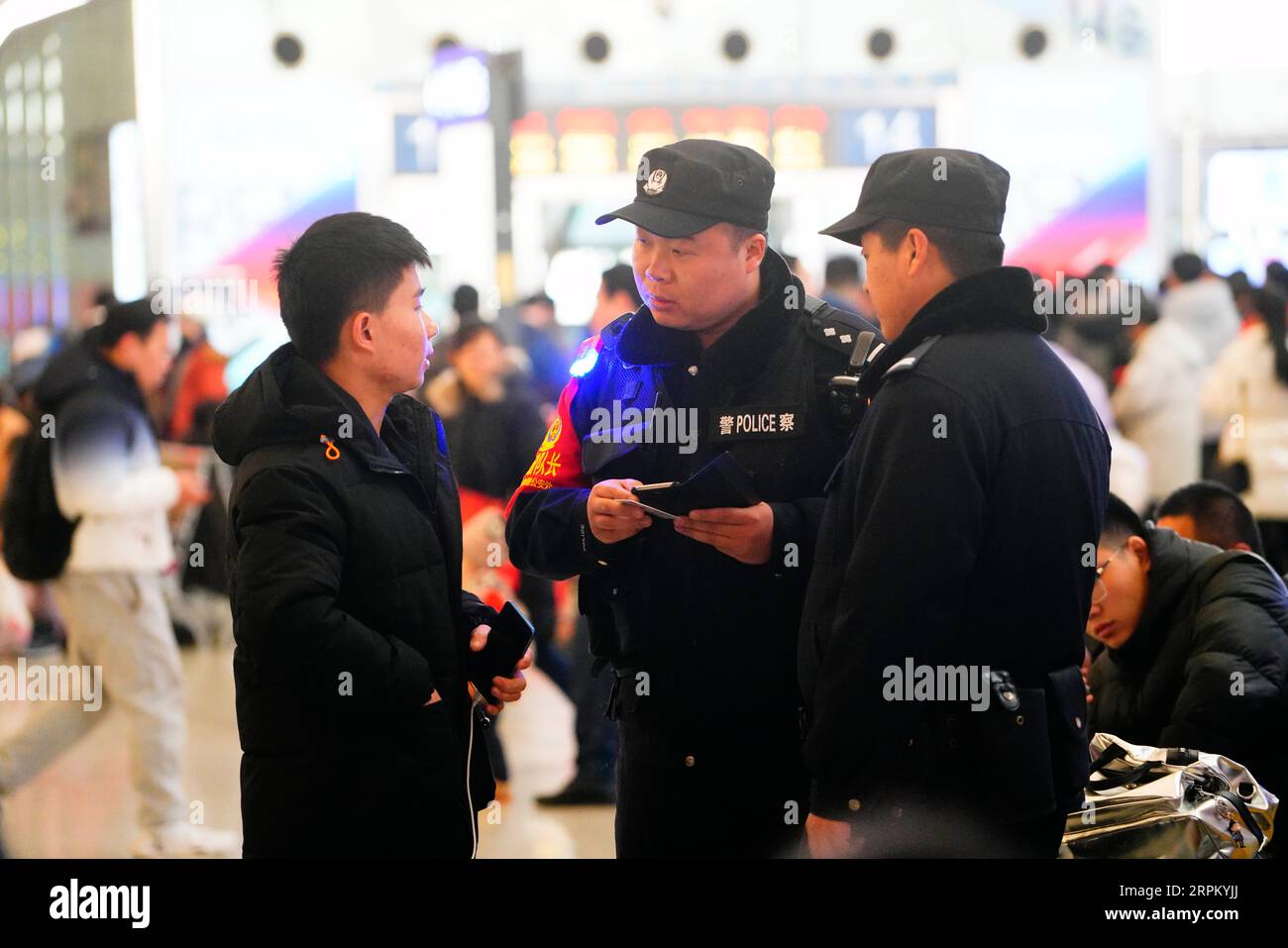 200121 -- SHIJIAZHUANG, Jan. 21, 2020 -- Zhang Peng C works at the security checkpoint of Shijiazhuang Railway Station in Shijiazhuang, north China s Hebei Province, Jan. 21, 2020. The Spring Festival is the biggest occasion for family reunion across China, but for the family of 6-year-old Zhang Anzhe, reunion opportunities are rare. Zhang s father Zhang Peng is a policeman working at the Shijiazhuang Railway Station police office while his mother Li Qi is a chief conductor on trains between Shijiazhuang and Wuhan. Both parents were so busy during the Spring Festival travel rush period. They h Stock Photo