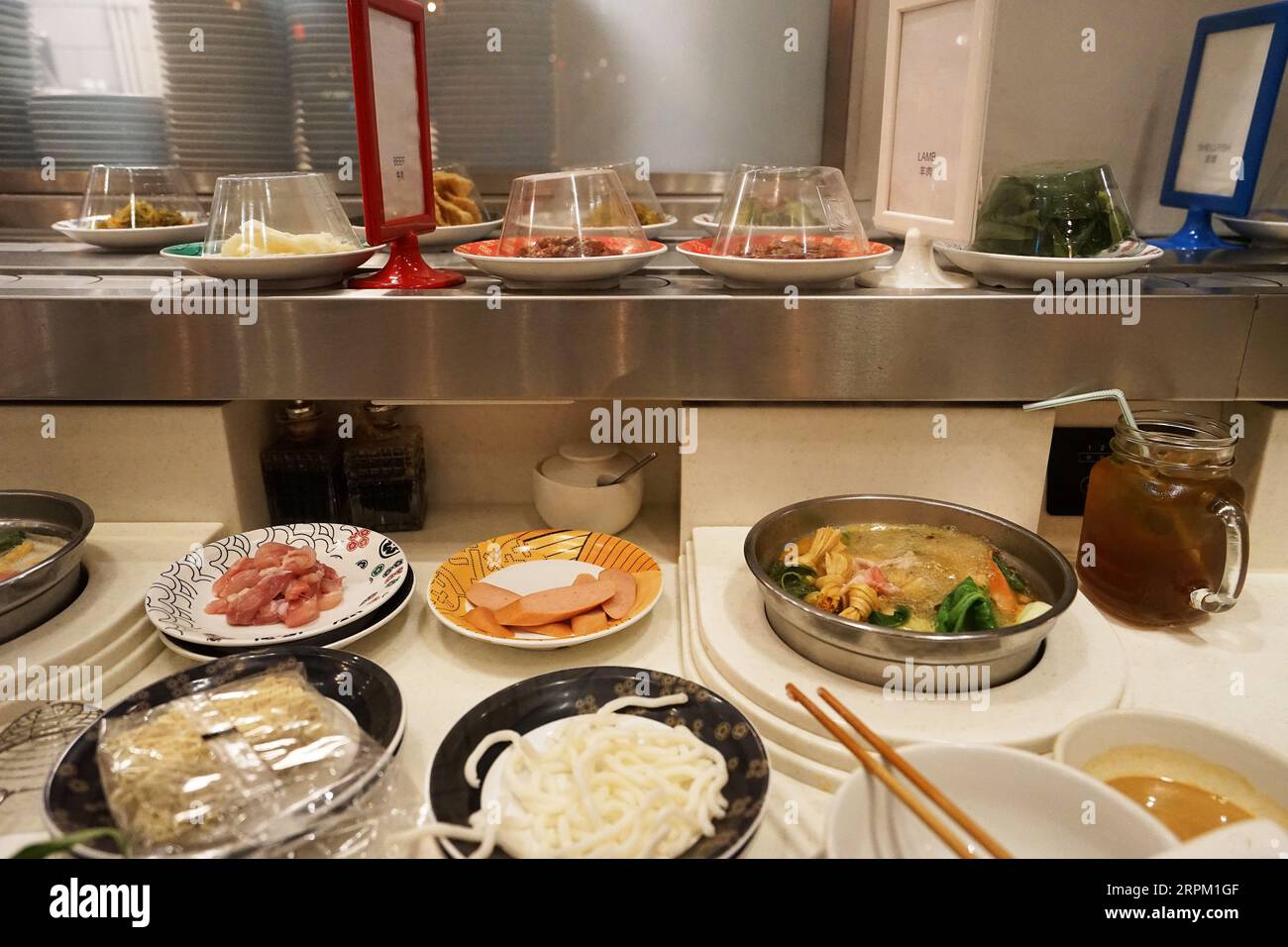 Table full of vegetables, Sliced Wagyu beef and pork, raw egg and dipping sauce at Shabu Shabu (Japanese hot pot) restaurant Stock Photo