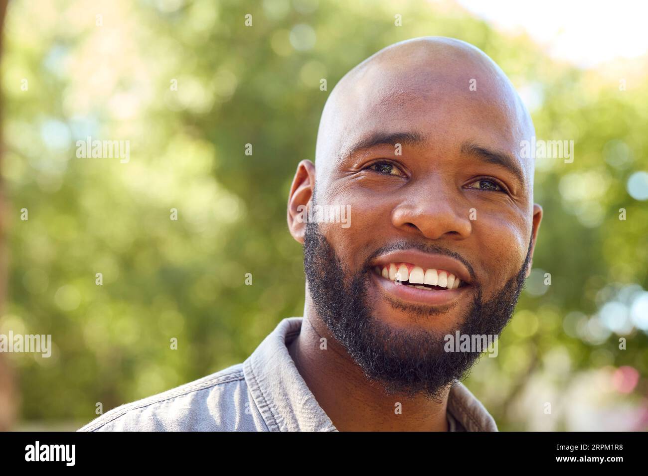 Portrait Of Smiling Man Standing Outdoors In Garden Park Or Countryside Stock Photo