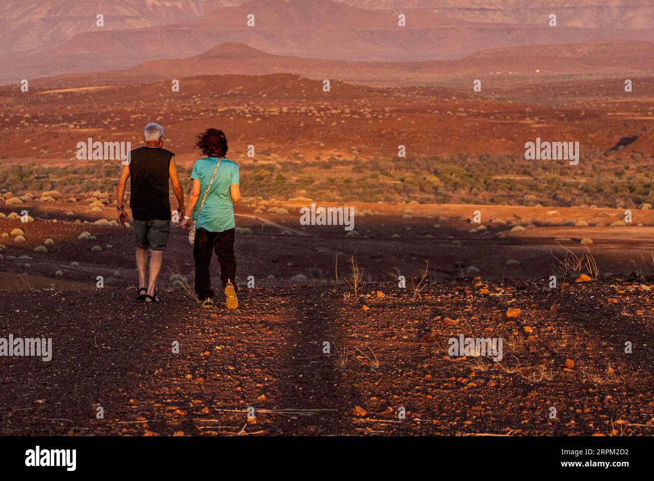 Couple looks at the sunset in the Namib desert Namibia Stock Photo