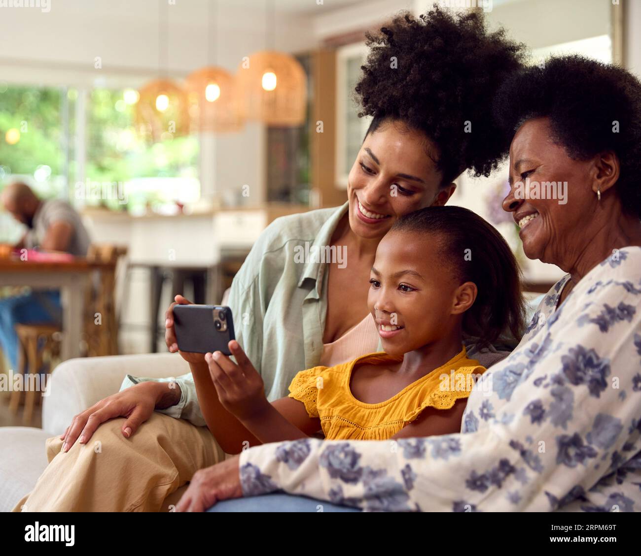 Multi-Generation Female Family Posing For Selfie On Mobile Phone Sitting On Sofa At Home Together Stock Photo