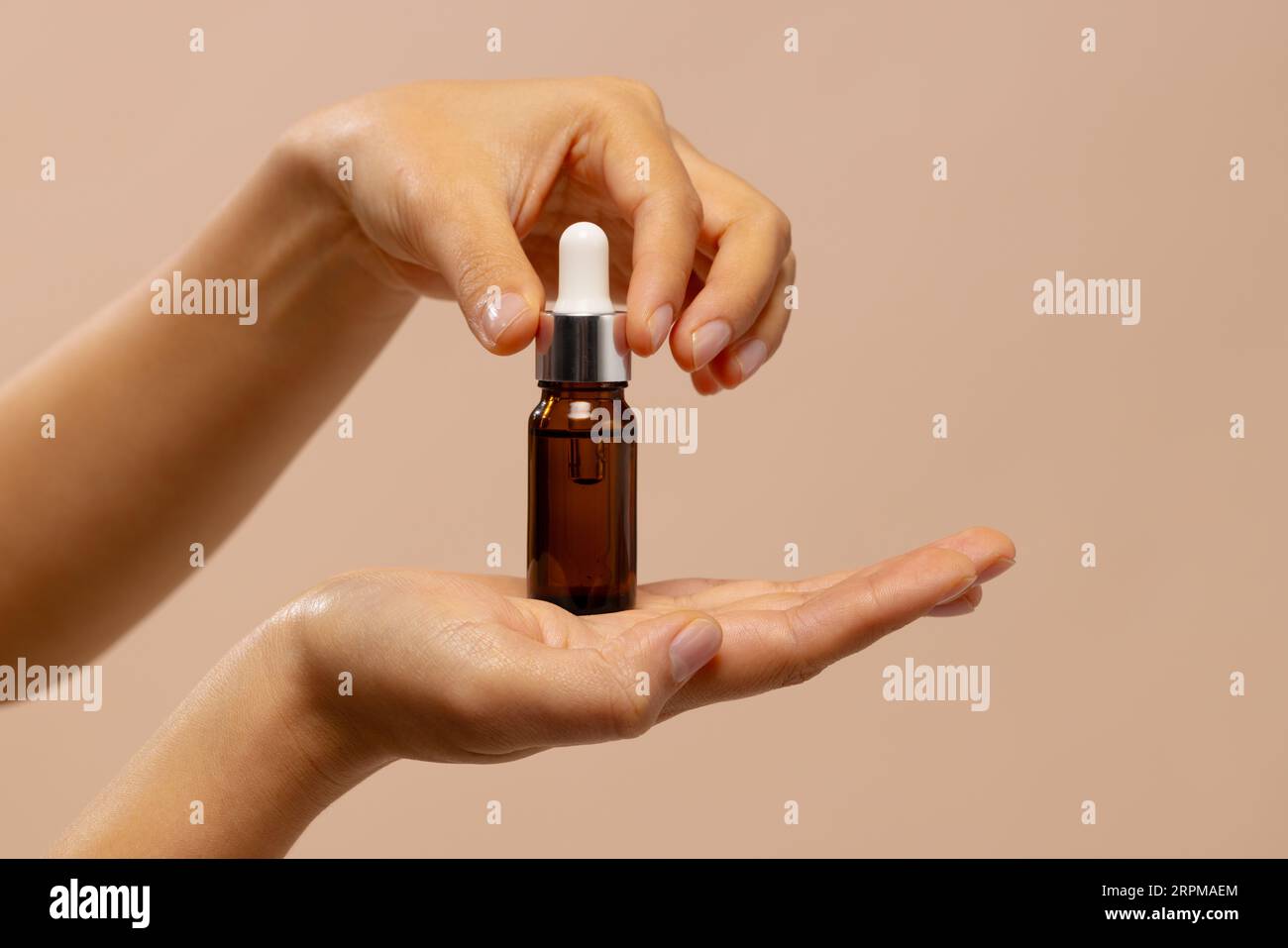 Hands of asian woman holding dropper bottle of skin tonic with copy space Stock Photo
