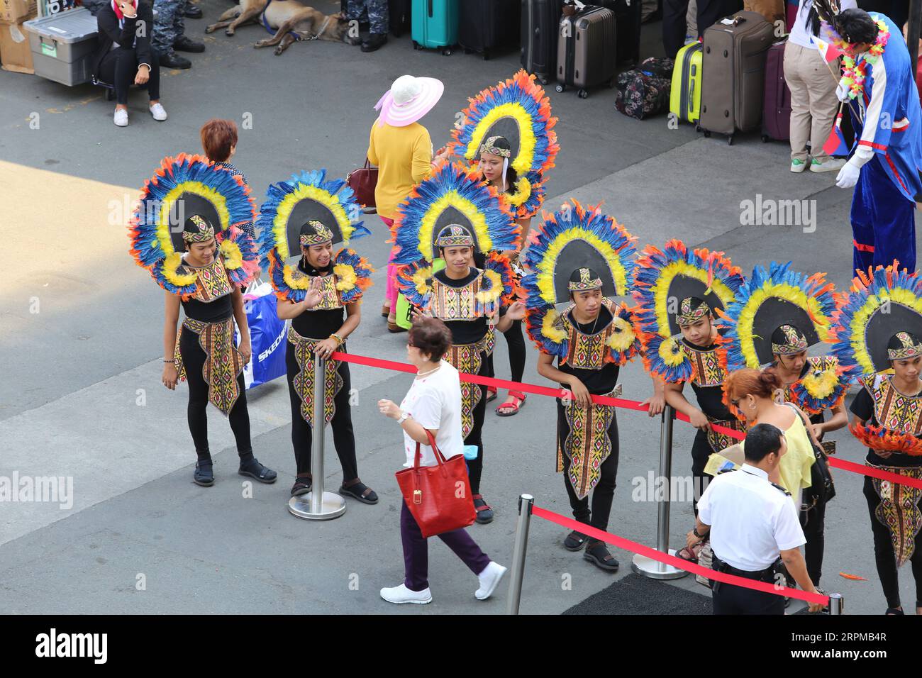 Philippine fiesta-themed welcome celebration for cruise ship at Manila pier : musicians with bamboo instruments, Filipino dancers, Higantes, flags Stock Photo