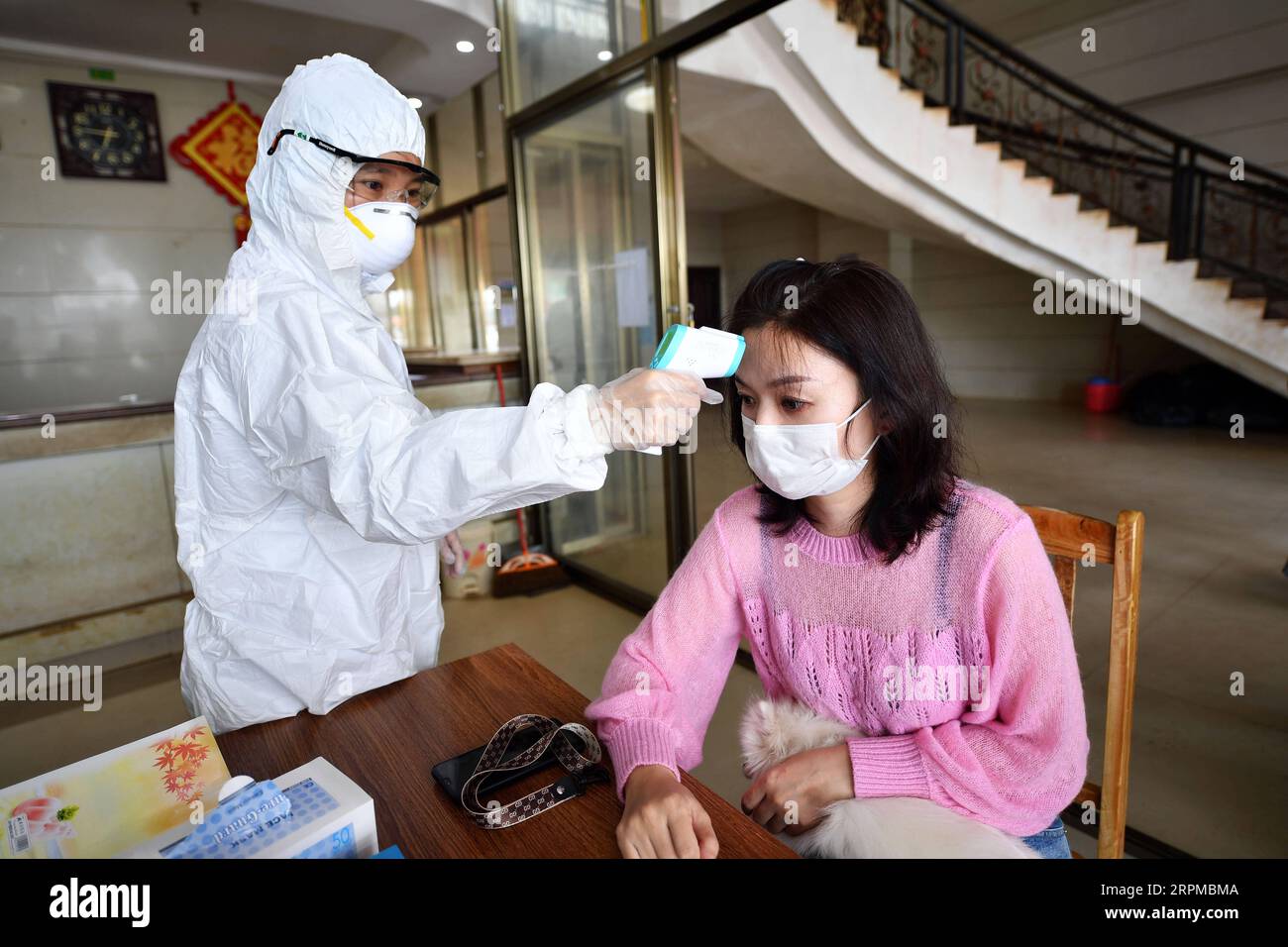 200207 -- HAIKOU, Feb. 7, 2020 -- A medical worker from Haikou of south China s Hainan Province measures body temperature of a passenger at an observation point in Xuwen County of Zhanjiang City, south China s Guangdong Province, Feb. 6, 2020. Qiongzhou Strait is a major passage into and out of Hainan Island. Since the start of the prevention and control of pneumonia caused by the novel coronavirus, Hainan and Guangdong have both moved the prevention and control threshold forward. Hainan has sent more than 160 joint anti-epidemic personnel from multiple departments to Zhanjiang of Guangdong Pr Stock Photo