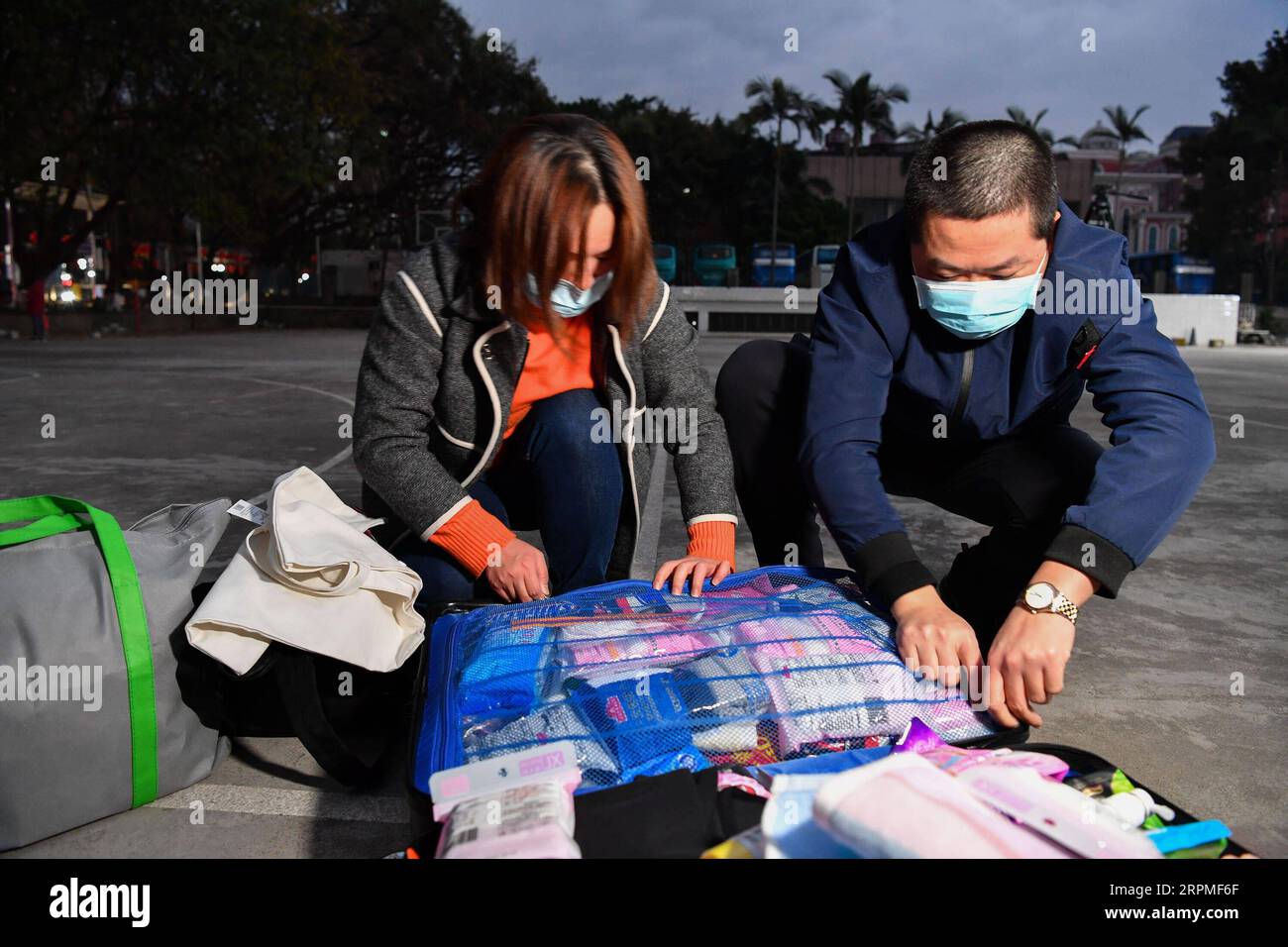 200211 -- GUANGZHOU, Feb. 11, 2020 -- Cao Sai L, a medical team member from Nanfang Hospital, packs the suitcase with her husband Huang XianyingR before leaving for Jingzhou of Hubei, in Guangzhou, south China s Guangdong Province, Feb. 10, 2020. A 109-member medical team of Guangdong departed on Monday for Jingzhou, central China s Hubei Province, as the first batch of medical staff sent to aid the novel coronavirus control efforts there. Guangdong will send altogether four batches, nearly a thousand medics, to Jingzhou under national plan.  CHINA-GUANGDONG-GUANGZHOU-MEDICAL TEAM-AID CN LiuxD Stock Photo