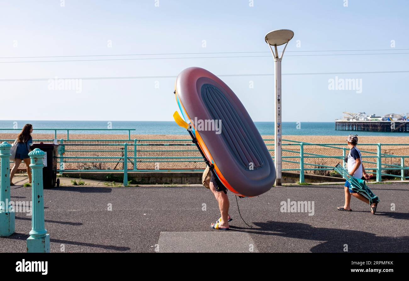 Brighton UK 5th September 2023 - A visitor with an inflatable dingy ...