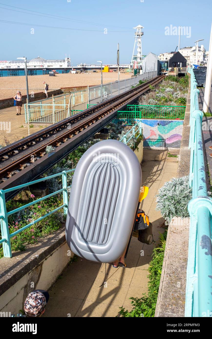 Brighton UK 5th September 2023 - A visitor with an inflatable dingy ...