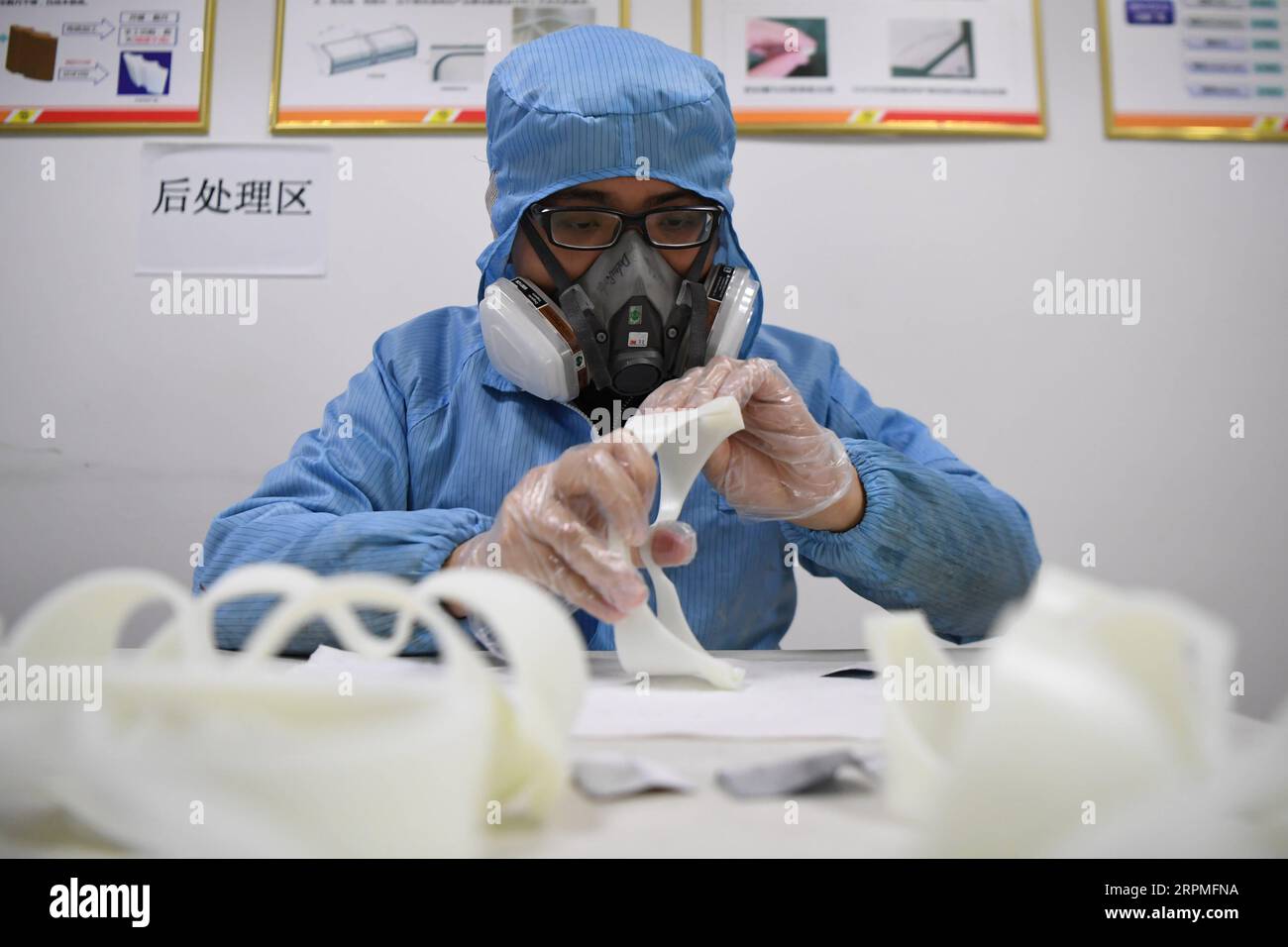 200211 -- CHANGSHA, Feb. 11, 2020 -- A worker polishes the spectacle frame of a pair of goggles made by 3D printer at the additive manufacturing research and application center of Hunan Vanguard Group Co., Ltd. in the economic development zone of Changsha City, central China s Hunan Province, Feb. 11, 2020. The company has been producing goggles for medical use with more than 50 3D printers working day and night recently. The first batch of 500 pairs of goggles it produced have been sent to Changsha and Huaihua to aid the novel coronavirus control efforts there.  CHINA-HUNAN-CHANGSHA-CORONAVIR Stock Photo