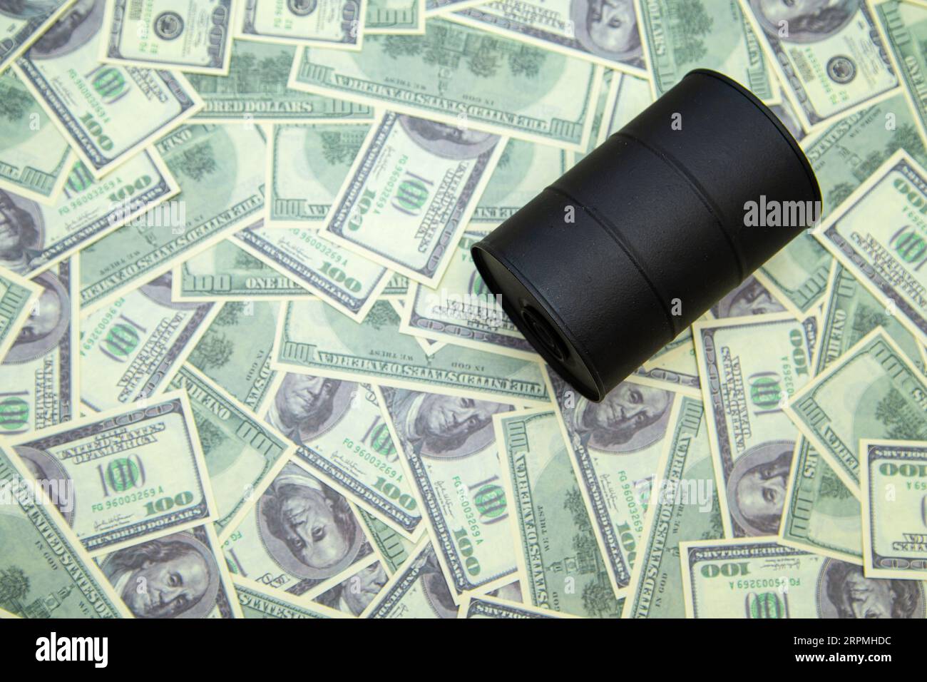 Barrel of oil on hundred dollar bills. The concept of oil, petrodollar