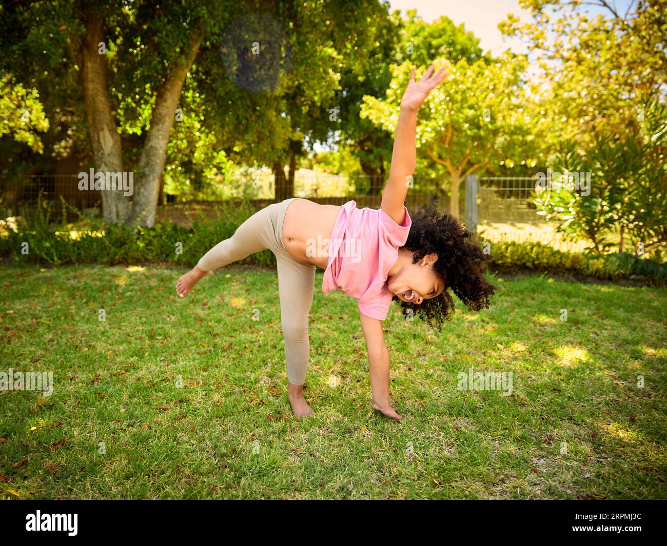 Active Young Girl Having Fun Turning Cartwheels Playing In Garden At Home Stock Photo