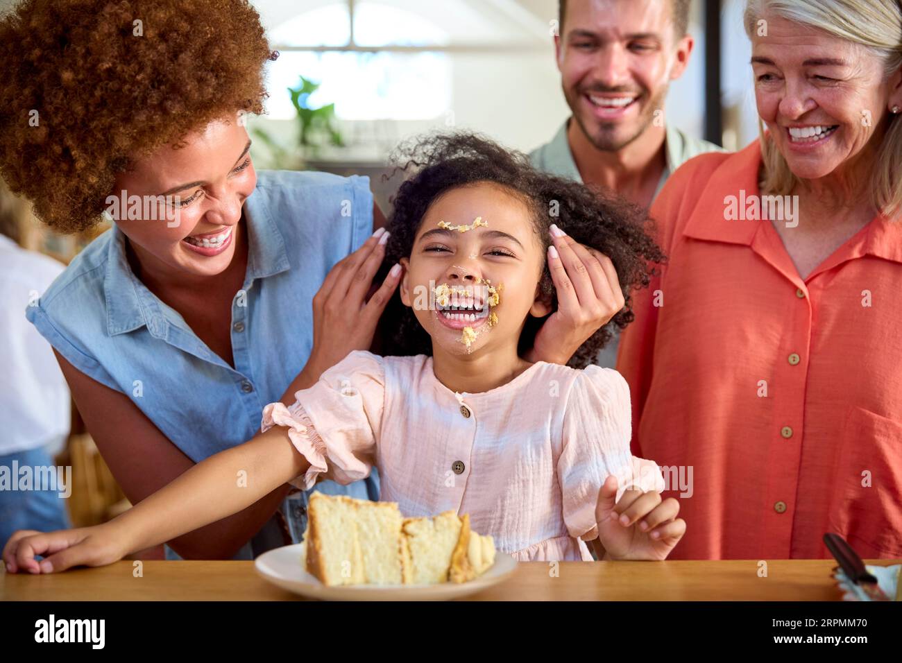 Granddaughter Making Mess With Cake As Multi-Generation Family ...