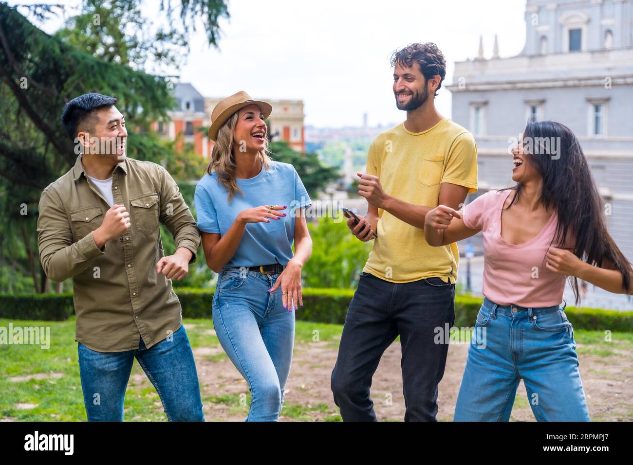 Group of multiethnic friends dancing in a park in the city at a