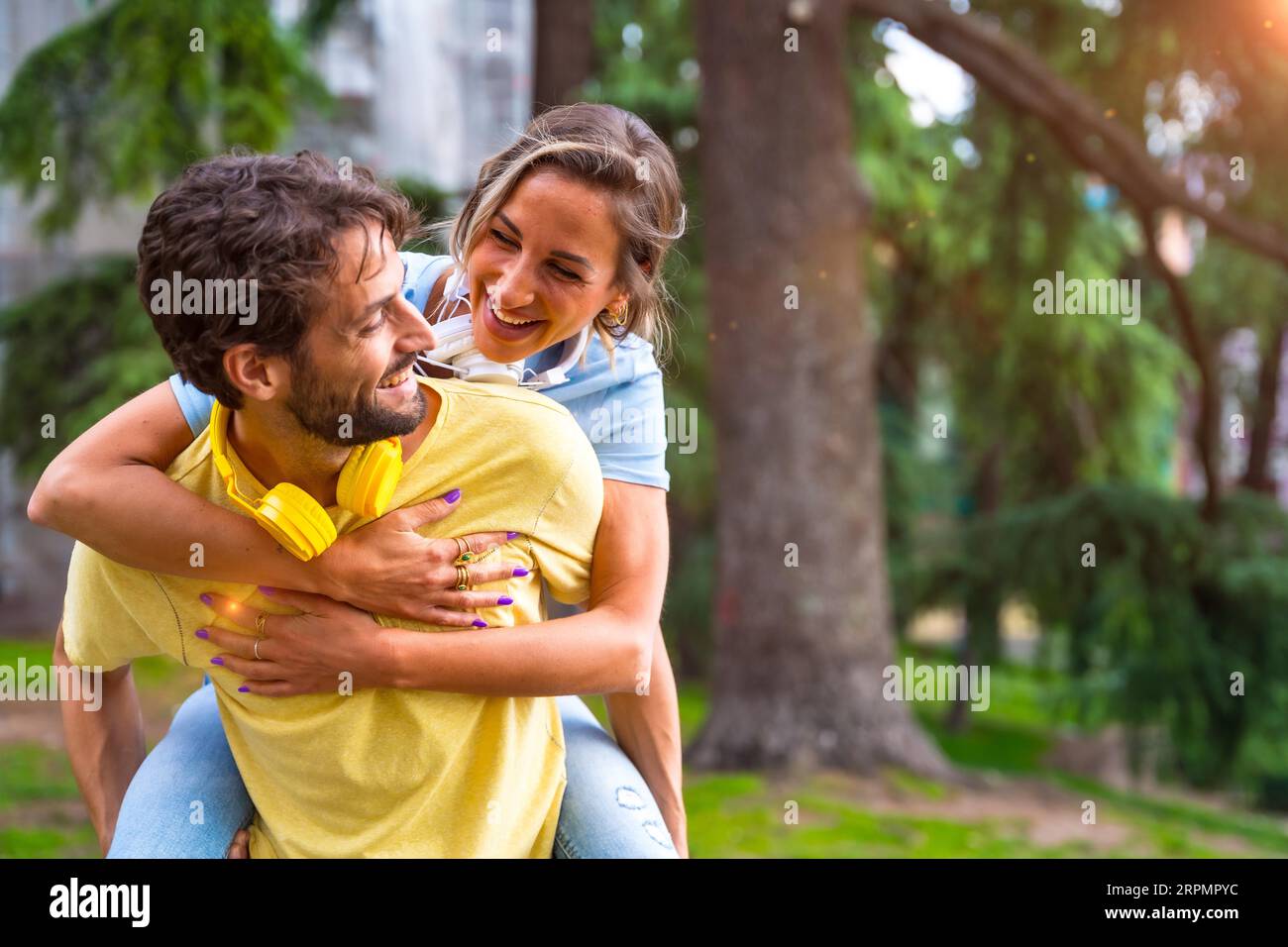 Couple in love in the city at sunset, standing on the back smiling mi having a fun time with each other Stock Photo