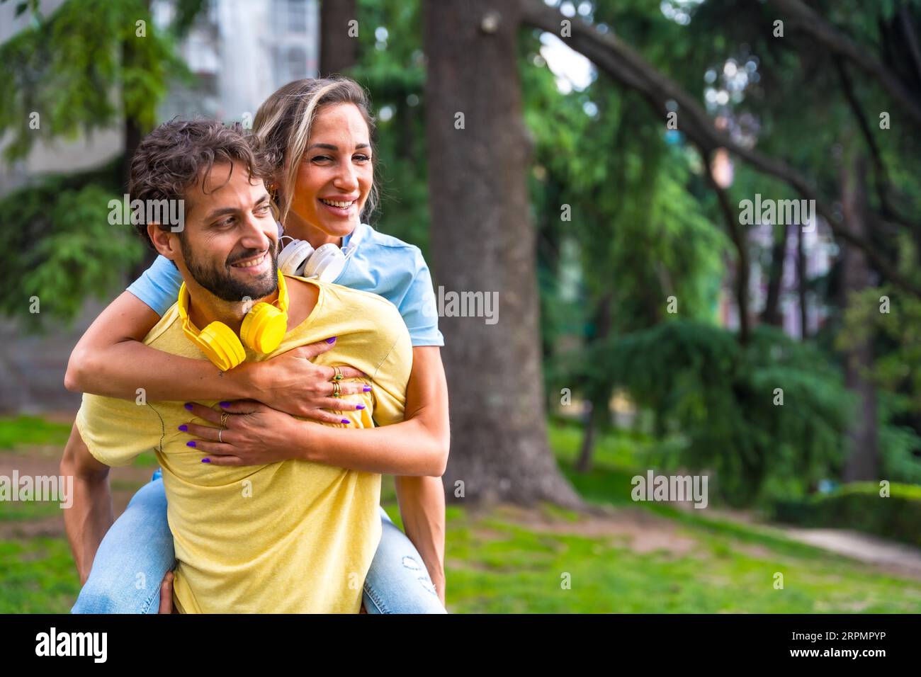 Couple in love in the city, climb on the back smiling mi having a fun time with each other Stock Photo