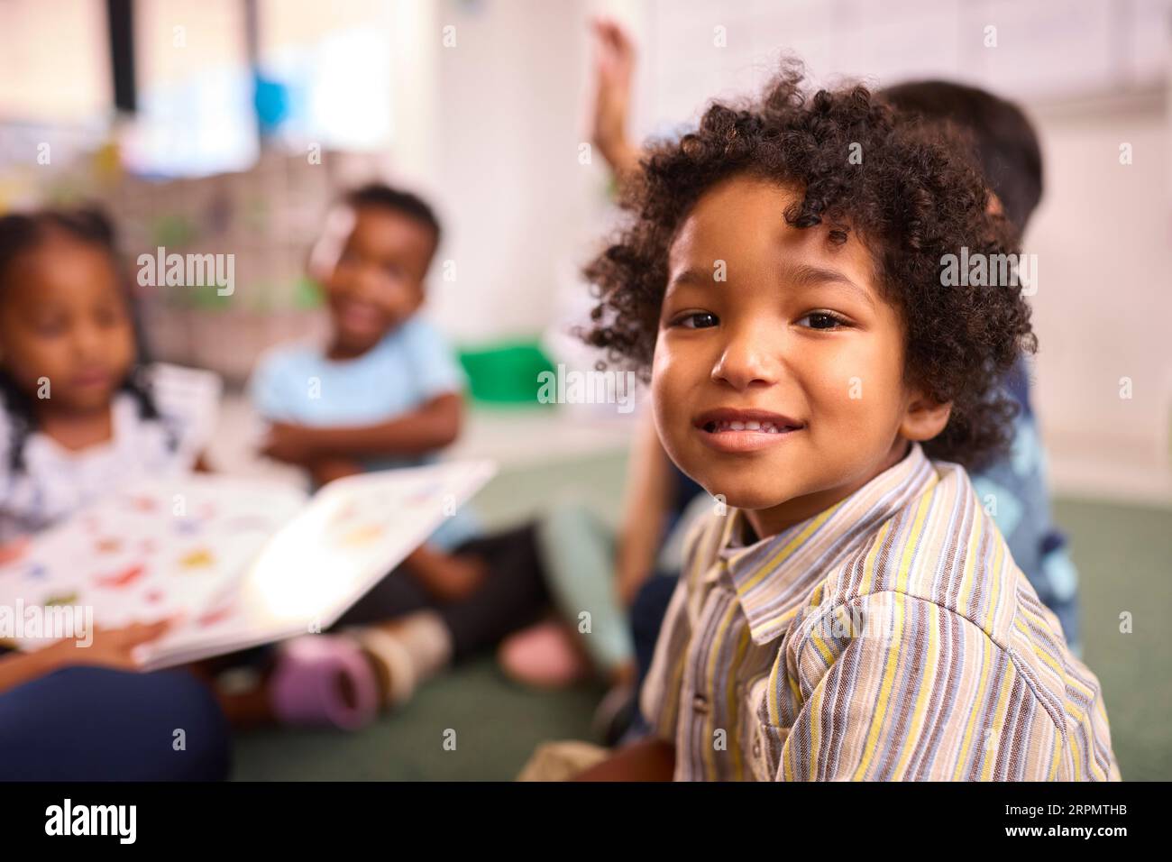 Portrait Of Smiling Male Elementary School Pupil Sitting In Classroom ...