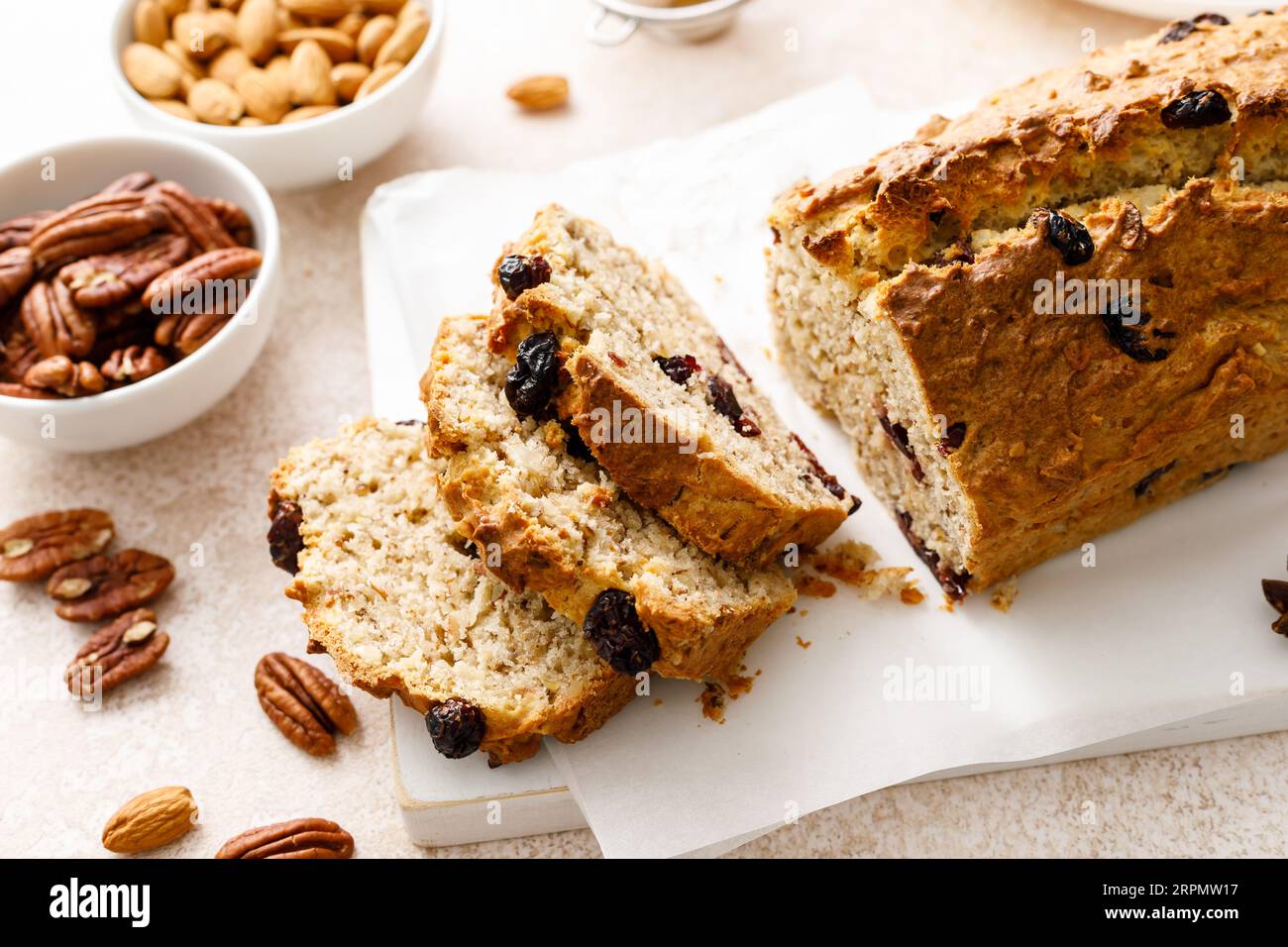 Fruitcake with cranberry, almond and pecan nuts sliced on a wooden board Stock Photo