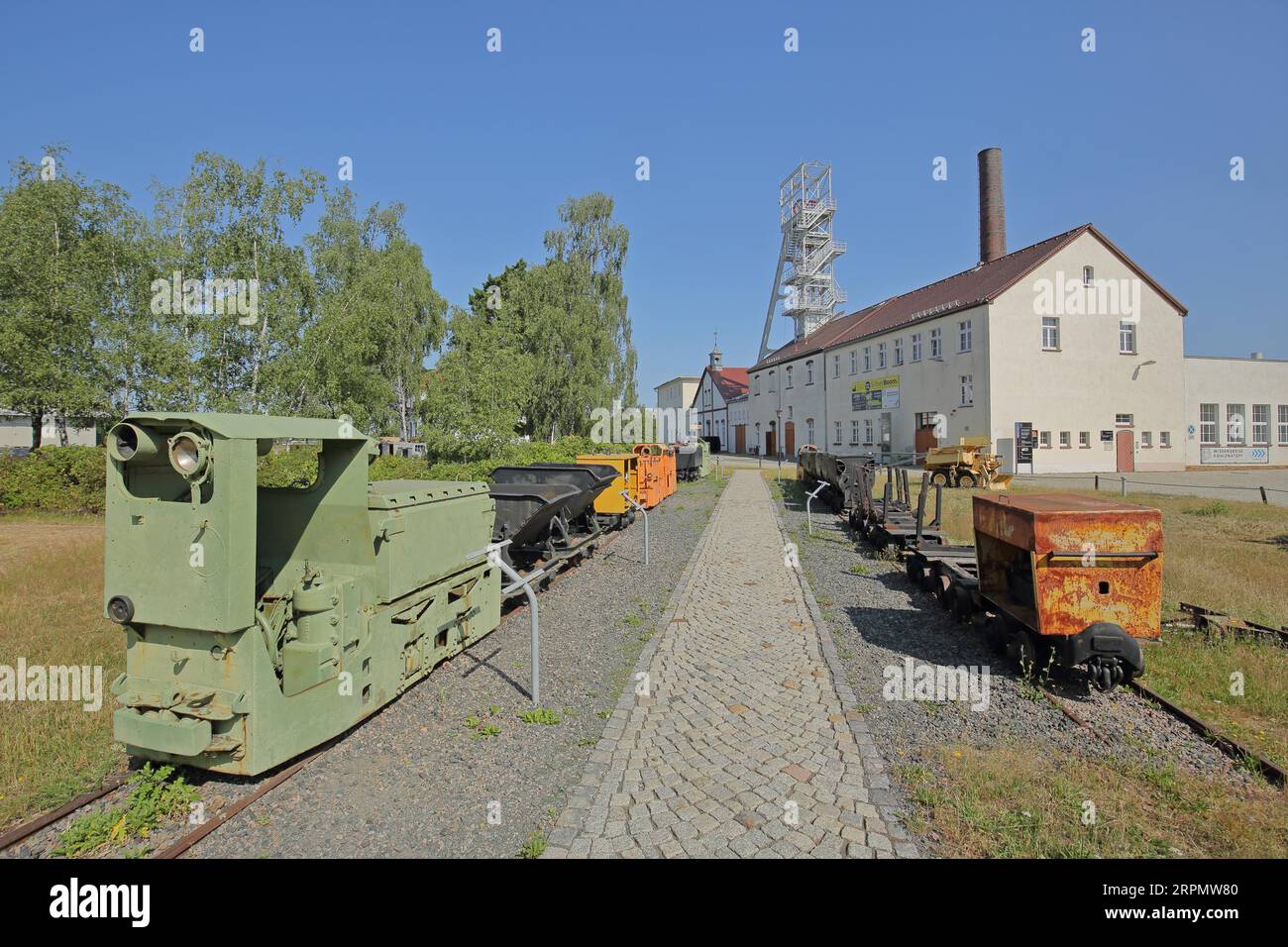 Rail vehicles Locomotive, lorries and dump truck with winding tower at the former mine Reiche Zeche Fundgrube Himmelfahrt, TU Bergakademie, UNESCO Stock Photo