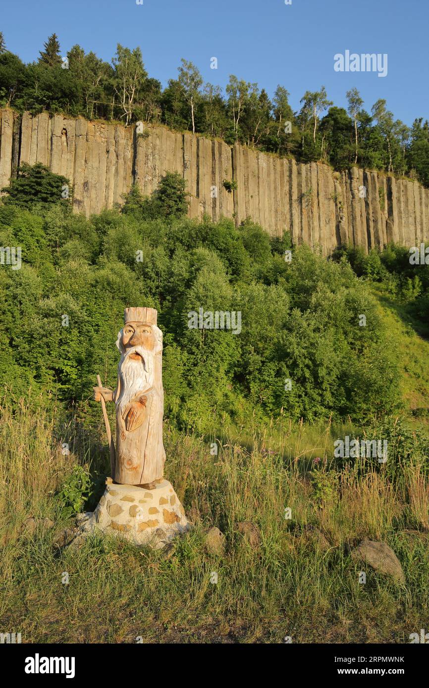 Organ pipes with basalt columns and wooden sculpture, wooden figure, chainsaw art, woodcarving, handicraft, man, figure, beard, staff, crown, rock Stock Photo