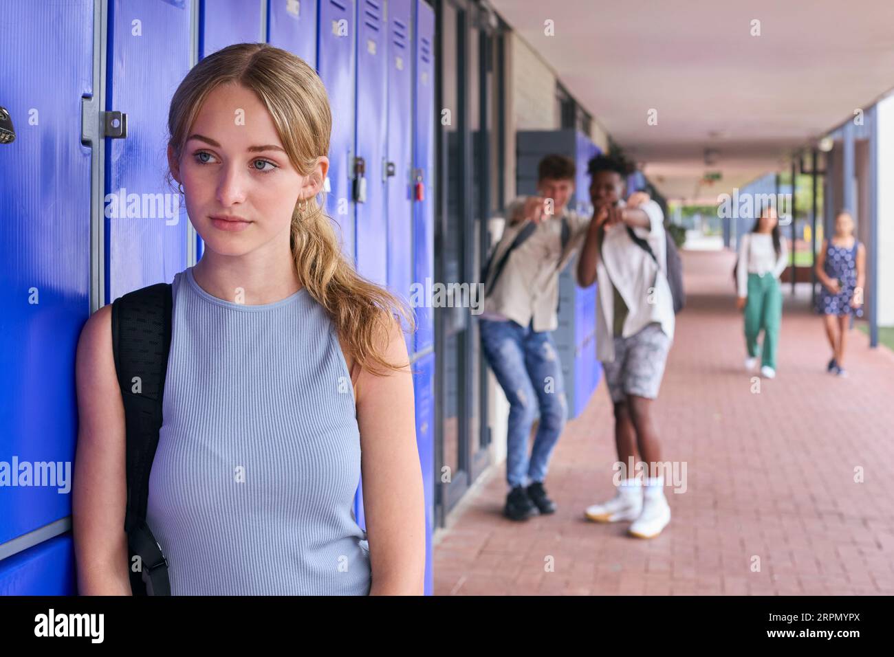 Unhappy Teenage Girl Outdoors At High School Being Teased Or Bullied Stock Photo