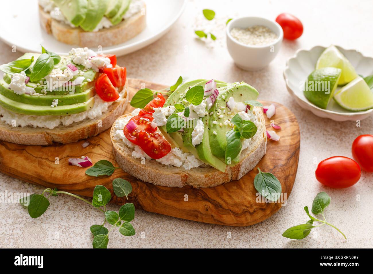 Avocado toast with cheese cottage, tomato and herbs for breakfast Stock Photo