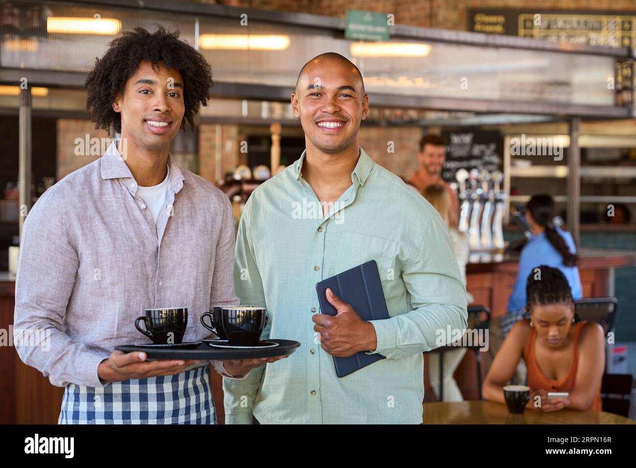 Portrait Of Male Manager With Digital Tablet And Waiter Working In Restaurant Or Coffee Shop Stock Photo
