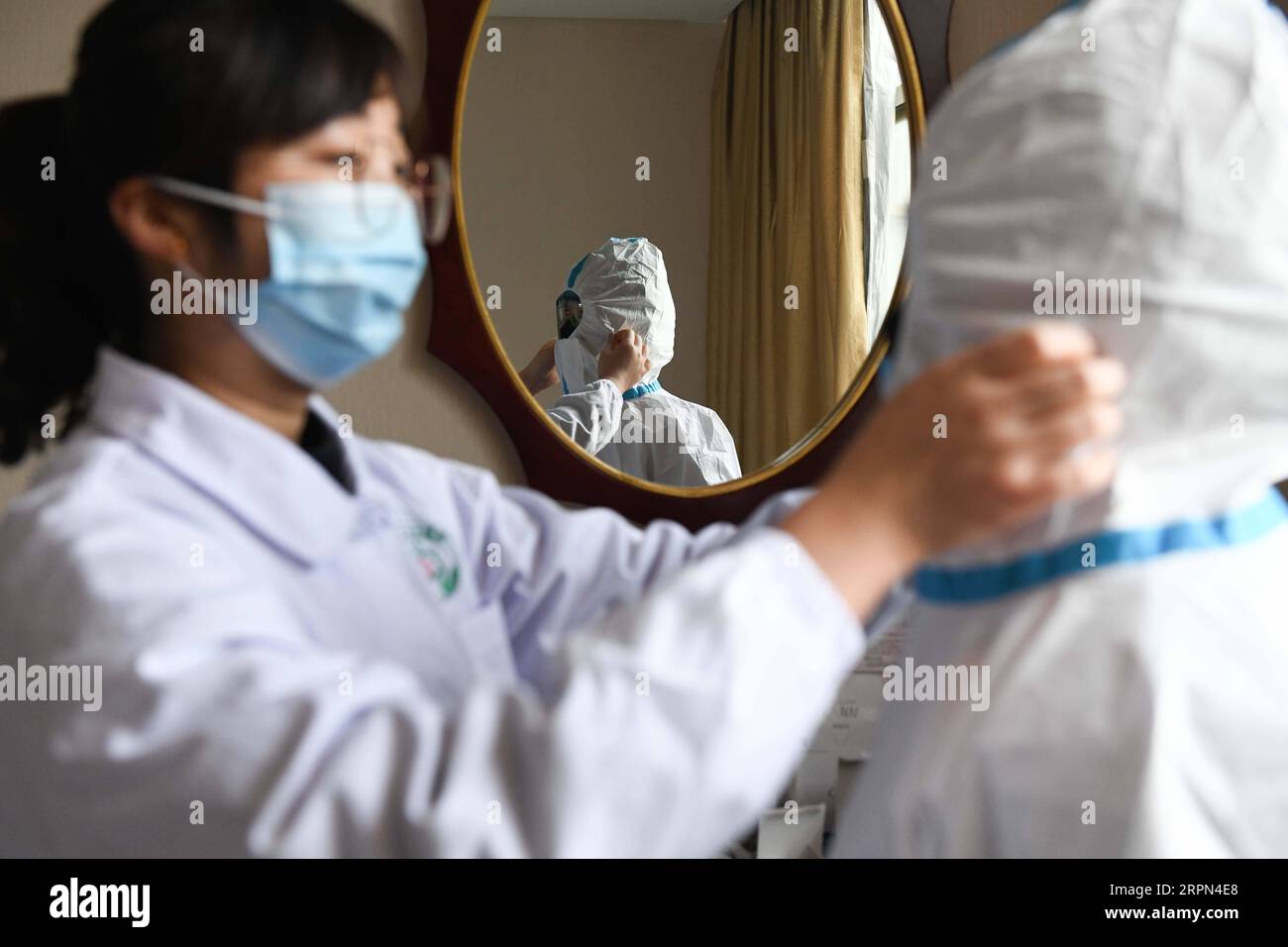 200222 -- HEFEI, Feb. 22, 2020 -- Health worker Sha Ximing R of Yonghe health station in Changning Community wears protective suit to enter the quarantine area to disinfect and deliver dinner in Hefei, east China s Anhui Province, Feb. 21, 2020. Thirty five staff members of the Anhui Branch of China Construction Eighth Engineering Division Corp. Ltd., who attended the construction of the makeshift Leishenshan hospital for novel coronavirus pneumonia patients in Wuhan, have recently come back to Hefei. They are now in quarantine for medical observation in a hotel in Hefei. Each of them has a se Stock Photo
