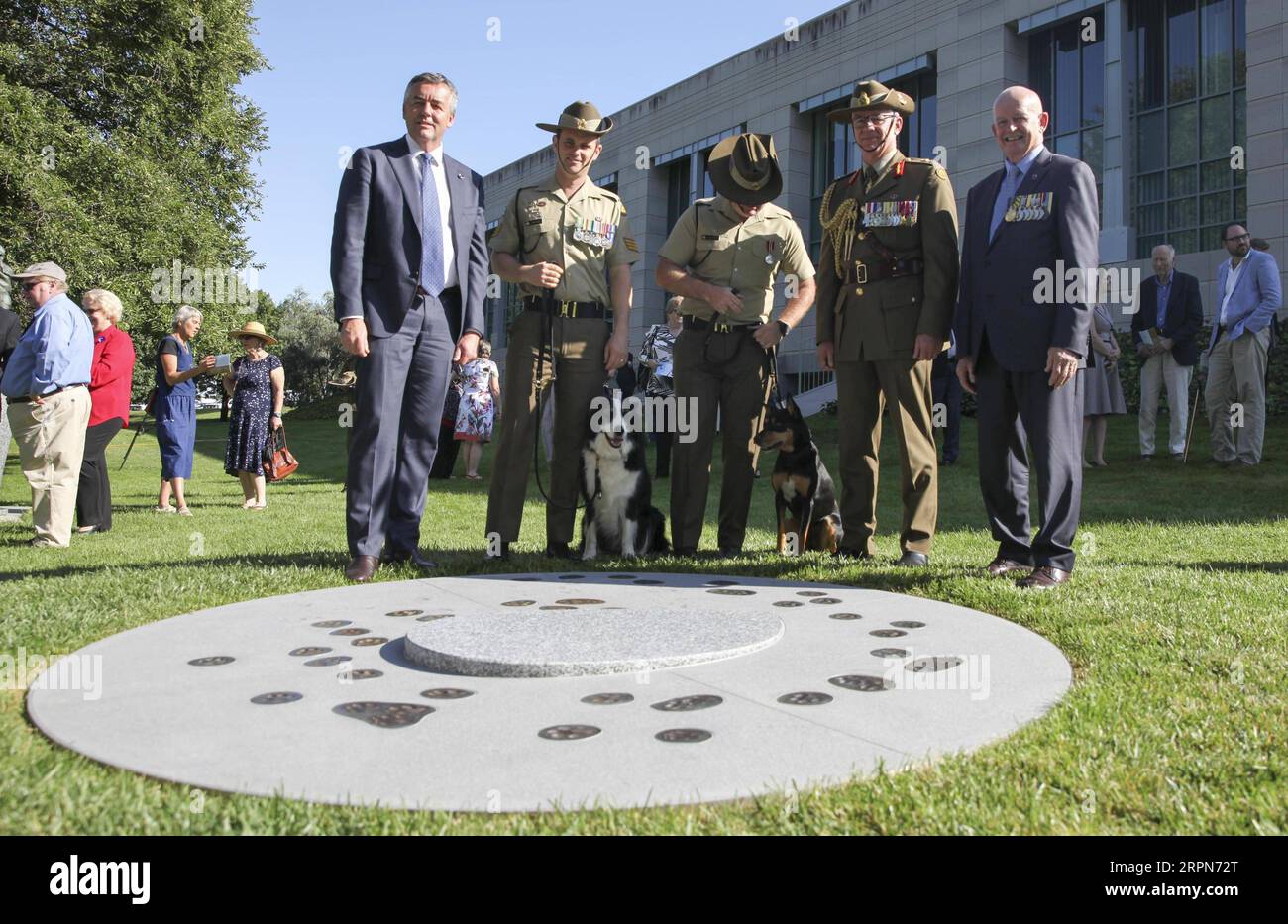 200224 -- CANBERRA, Feb. 24, 2020 Xinhua -- Darren Chester1st L, the Australian Minister for Veterans and Defence Personnel, poses for photos with military officers and their military working dogs in front of a new memorial dedicated to military working dogs and their handlers at Australian War Memorial AWM in Canberra, Australia, Feb. 24, 2020. AWM on Monday unveiled a new memorial dedicated to military working dogs and their handlers. Monday is the National Day for War Animals in Australia. Photo by Liu Changchang/Xinhua AUSTRALIA-CANBERRA-MEMORIAL-MILITARY WORKING DOGS PUBLICATIONxNOTxINxCH Stock Photo