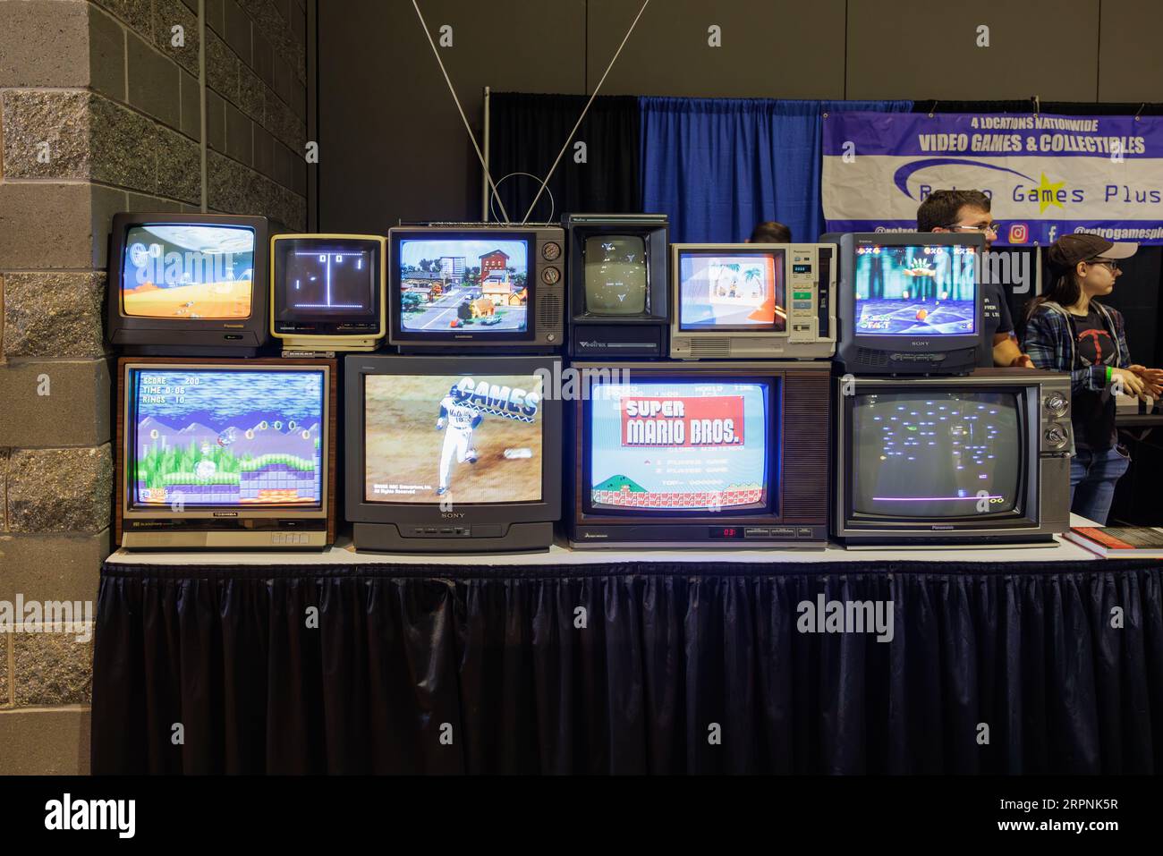 An array of various CRT television sets are displayed on a solid white