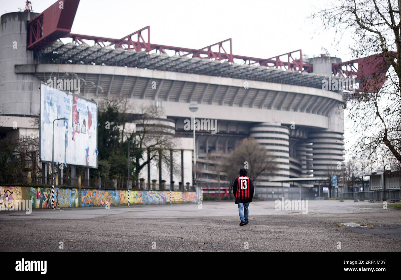 200302 -- MILAN, March 2, 2020 Xinhua -- A fan of AC Milan walks outside the San Siro stadium after a Serie A soccer match between AC Milan and Genoa was postponed due to the recent coronavirus outbreak in Milan, Italy, March 1, 2020. The number of Italians infected by the coronavirus continues to accelerate, Giovanni Rezza, head of the Italian High Institute of Health s Department of Infectious Diseases, said Sunday, adding that the country was at least a week away from seeing a peak in the outbreak. According to Angelo Borrelli, Civil Protection Department chief and Extraordinary Commissione Stock Photo