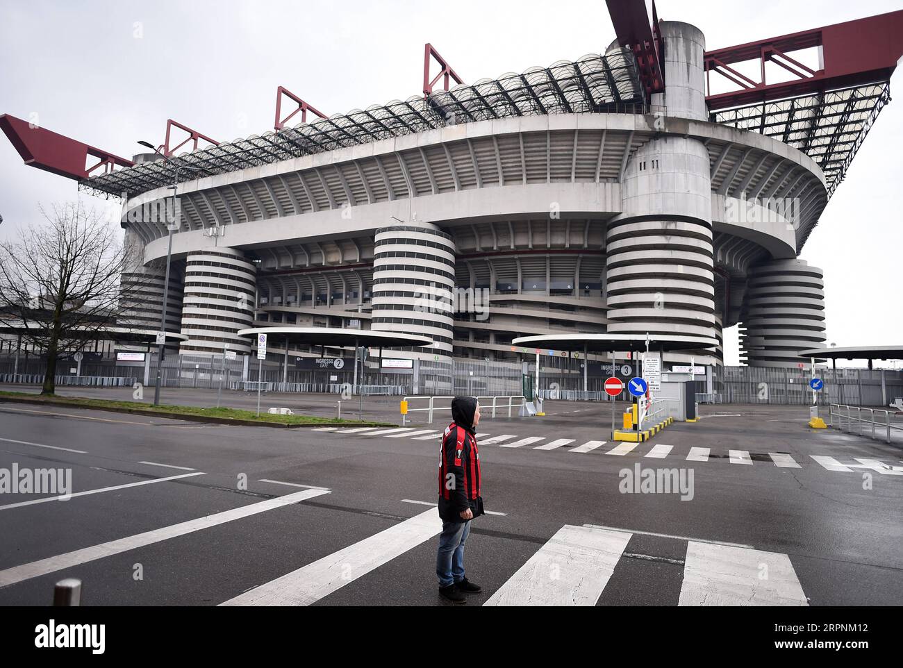 200302 -- MILAN, March 2, 2020 Xinhua -- A fan of AC Milan stands outside the San Siro stadium after a Serie A soccer match between AC Milan and Genoa was postponed due to the recent coronavirus outbreak in Milan, Italy, March 1, 2020. The number of Italians infected by the coronavirus continues to accelerate, Giovanni Rezza, head of the Italian High Institute of Health s Department of Infectious Diseases, said Sunday, adding that the country was at least a week away from seeing a peak in the outbreak. According to Angelo Borrelli, Civil Protection Department chief and Extraordinary Commission Stock Photo