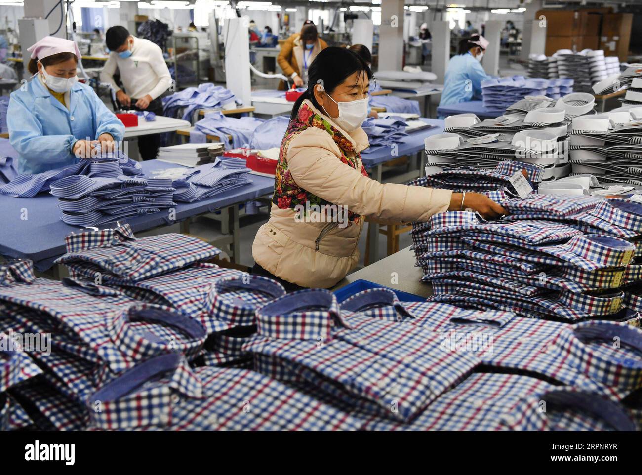 200304 -- MIANXIAN, March 4, 2020 -- Staff work at a clothing company in Mianxian County, northwest China s Shaanxi Province, March 4, 2020. All of the 79 industrial enterprises above designated size in the county have resumed production in an orderly way amid the novel coronavirus outbreak.  CHINA-SHAANXI-MIANXIAN-PRODUCTION RESUMPTION CN TaoxMing PUBLICATIONxNOTxINxCHN Stock Photo