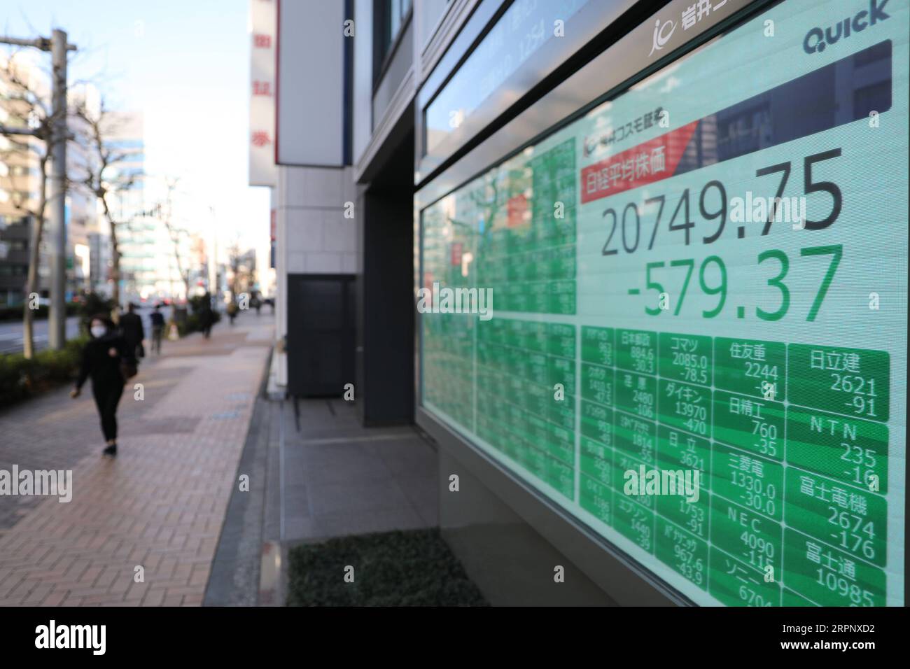 200306 -- TOKYO, March 6, 2020 -- A passenger wearing a mask passes by an electronic board showing the stock index in Tokyo, Japan, on March 6, 2020. Tokyo stocks closed sharply lower Friday as investor sentiment was risk-averse from the outset following a global equities rout triggered by an escalation in concern over the spread of the coronavirus.  JAPAN-TOKYO-STOCK DuxXiaoyi PUBLICATIONxNOTxINxCHN Stock Photo