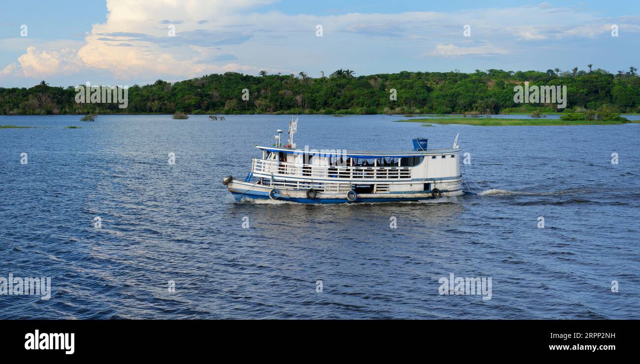 Traditional wooden boat navigating on the Trombetas River, Para State, Brazil Stock Photo