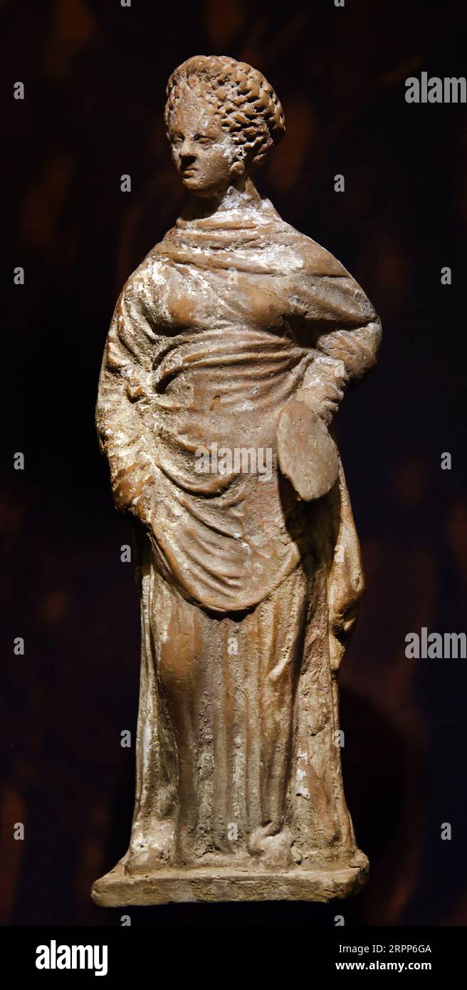 Terracotta female figurine of the Tanagran type, dressed in hiton and himation holding a fan 4th-2th BC, Athens, Museum, Greek, Greece. . Museum of Cycladic Art Stock Photo
