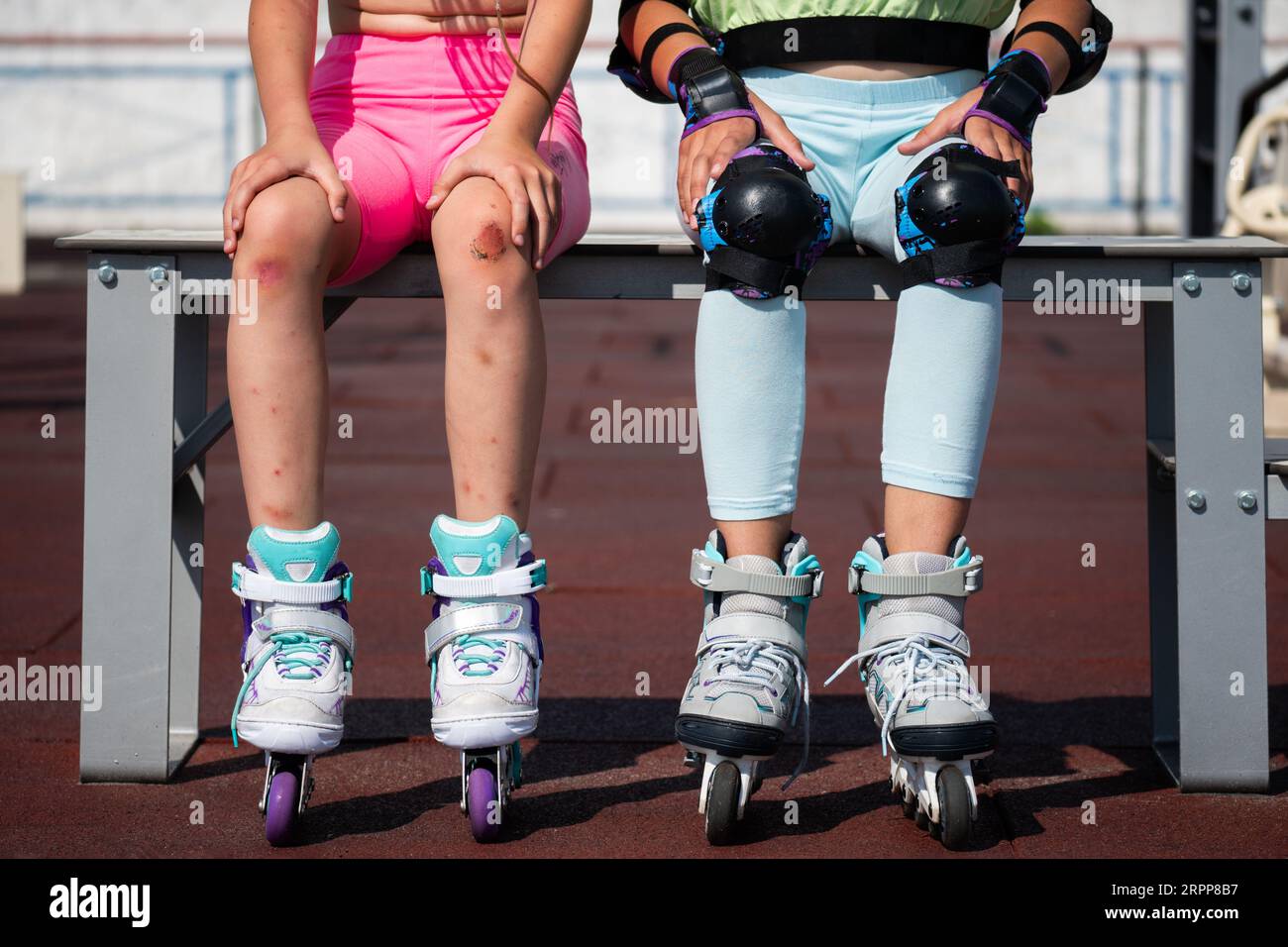 schoolgirls are sitting on a bench after roller skating. girls in