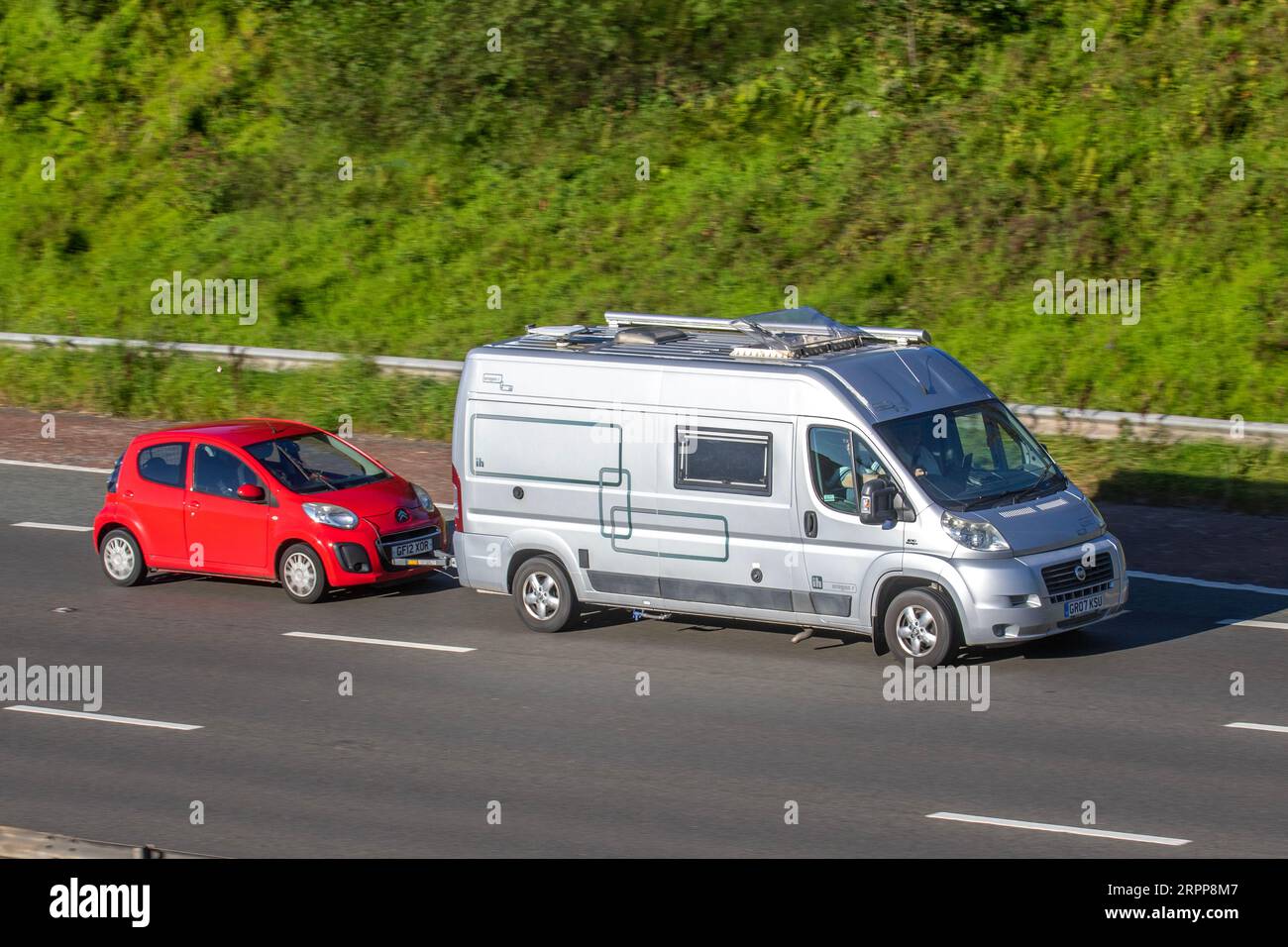 2007 Fiat Ducato 35 120 M-J LWB Oregan R  2.3 35 LWB H/R MJ 120, towing  2012 Citroen C1 VTR; travelling at speed on the M6 motorway in Greater Manchester, UK Stock Photo
