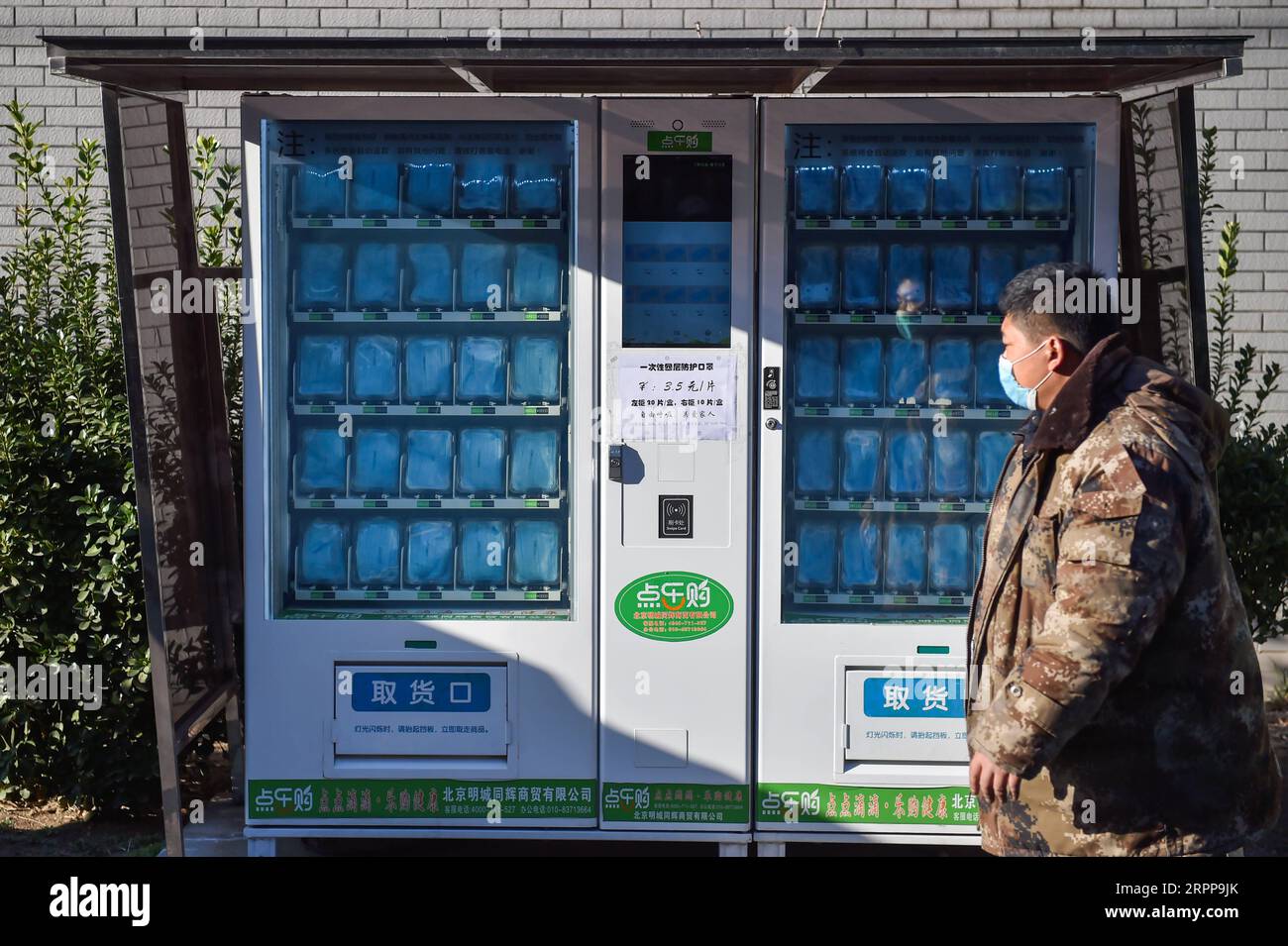 200314 -- BEIJING, March 14, 2020 -- A man walks past a newly-built face mask vending machine in Fengtai District of Beijing, capital of China, March 13, 2020.  XINHUA PHOTOS OF THE DAY PengxZiyang PUBLICATIONxNOTxINxCHN Stock Photo