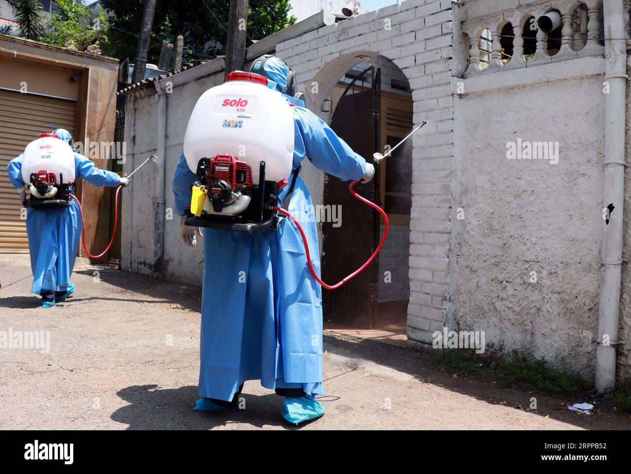 200314 -- COLOMBO, March 14, 2020 -- Health workers wearing protective suits spray disinfectant on a housing complex in Colombo, Sri Lanka, March 14, 2020. The number of confirmed cases of COVID-19 in Sri Lanka rose to 10 on Saturday evening with the latest being two females aged 56 and 17 years old, the Health Ministry said in a statement here. All the patients are currently receiving treatment at the Infectious Disease Hospital on the outskirts of the capital and the Polonnaruwa Hospital in north central Sri Lanka. Photo by /Xinhua SRI LANKA-COLOMBO-COVID-19 AjithxPerera PUBLICATIONxNOTxINxC Stock Photo
