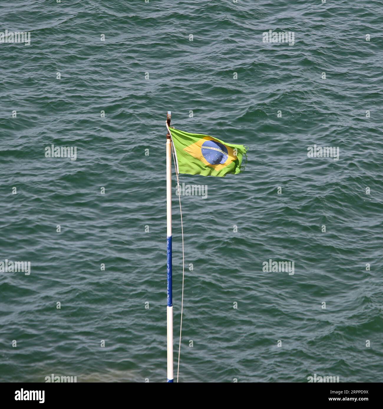 Brasil Flag at Pole Sea Water Sunny Summer Day Stock Photo