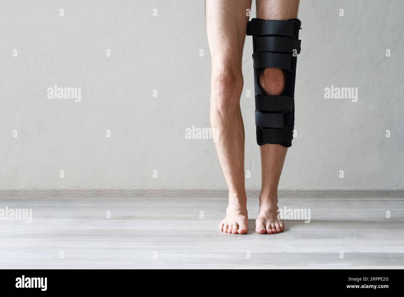 Leg brace on knee against gray wall background, knee brace support for ...
