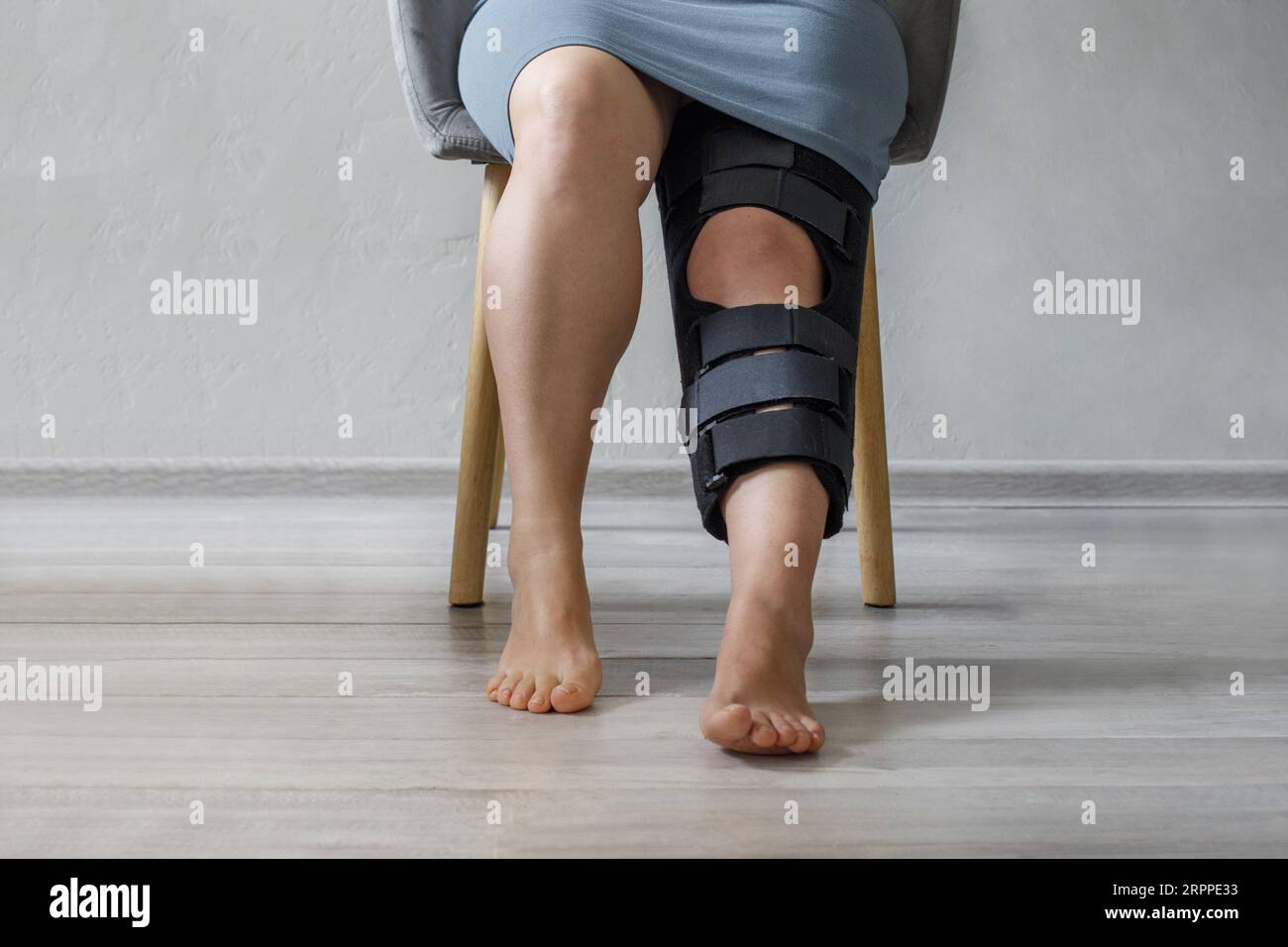 Woman wearing leg brace with adjustable side panels to immobilize and support her knee after